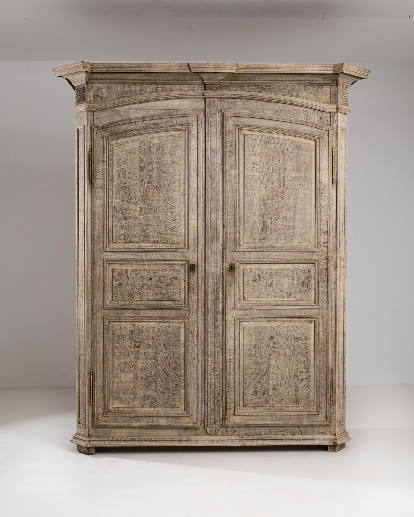 This provincial oak armoire combines a statuesque design with a subtle natural finish. Built in France in the 1800s, the burled grain of the oak provides elegant organic ornament, while the carved moldings —columns, an arched top-rail and a dramatic