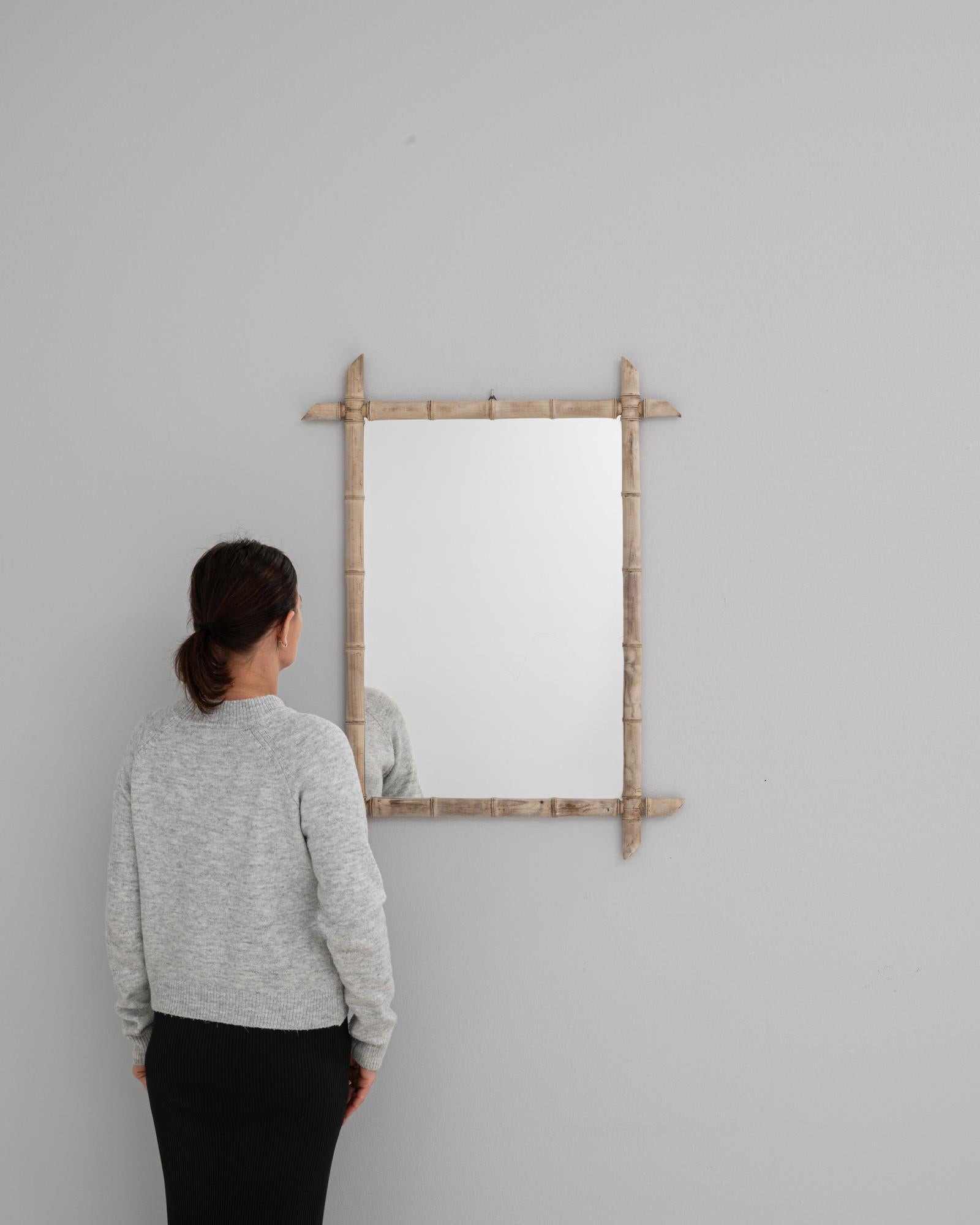 Ce miroir en chêne français du XIXe siècle est fabriqué dans un style de faux bambou, illustrant la fascination pour les motifs exotiques de l'époque. Le cadre en chêne sculpté imite la forme segmentée et la texture naturelle du bambou, avec des