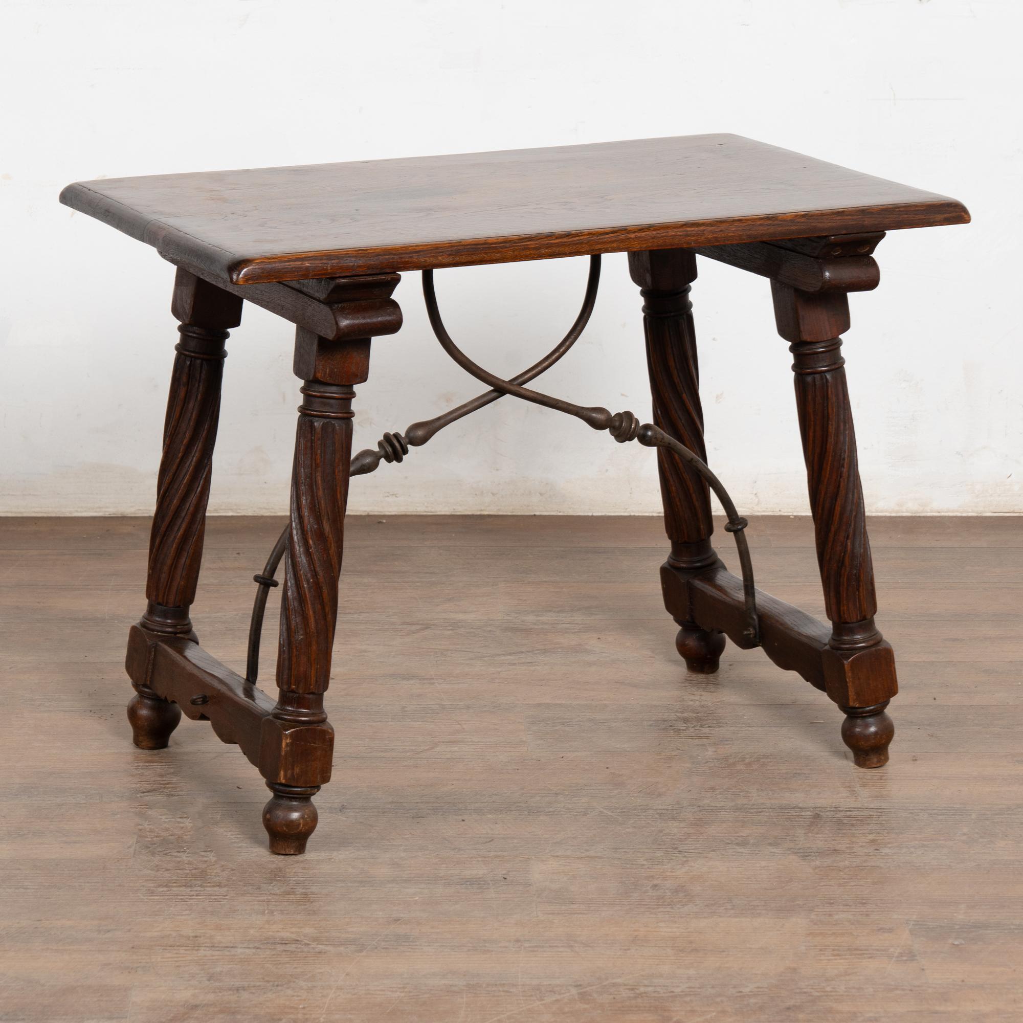 Table d'appoint en chêne français de style baroque, avec des pieds tournés et sculptés, reliés par un châssis en fer orné.
Chêne foncé avec une patine profonde, des éraflures, des rayures, des taches et de légères goujures dues à l'âge (en