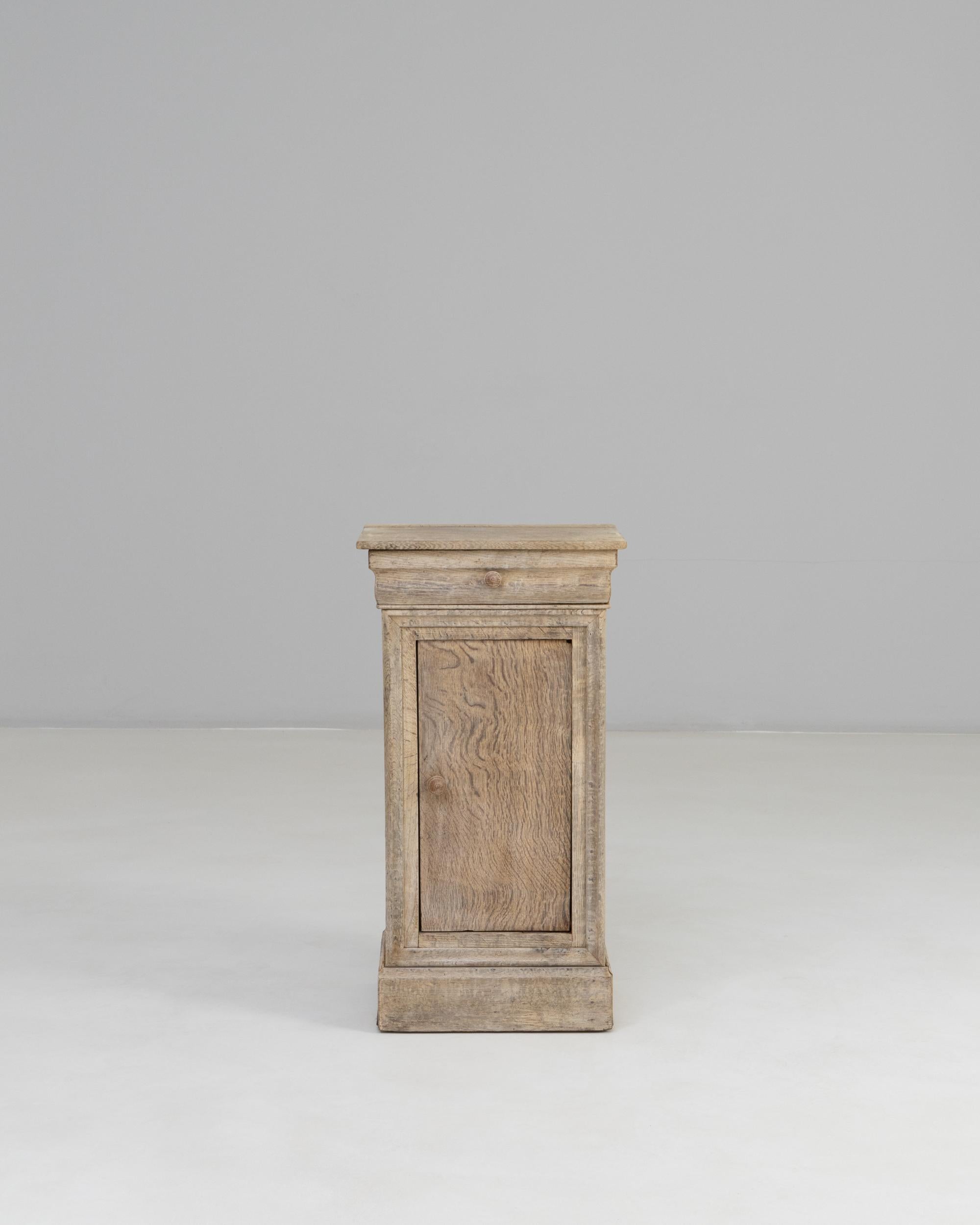 19th Century French Oak Bedside Table. This understated yet beautifully crafted bedside table reflects the quiet elegance of 19th-century French design. Made from solid oak with a naturally weathered patina, it features a single paneled door that