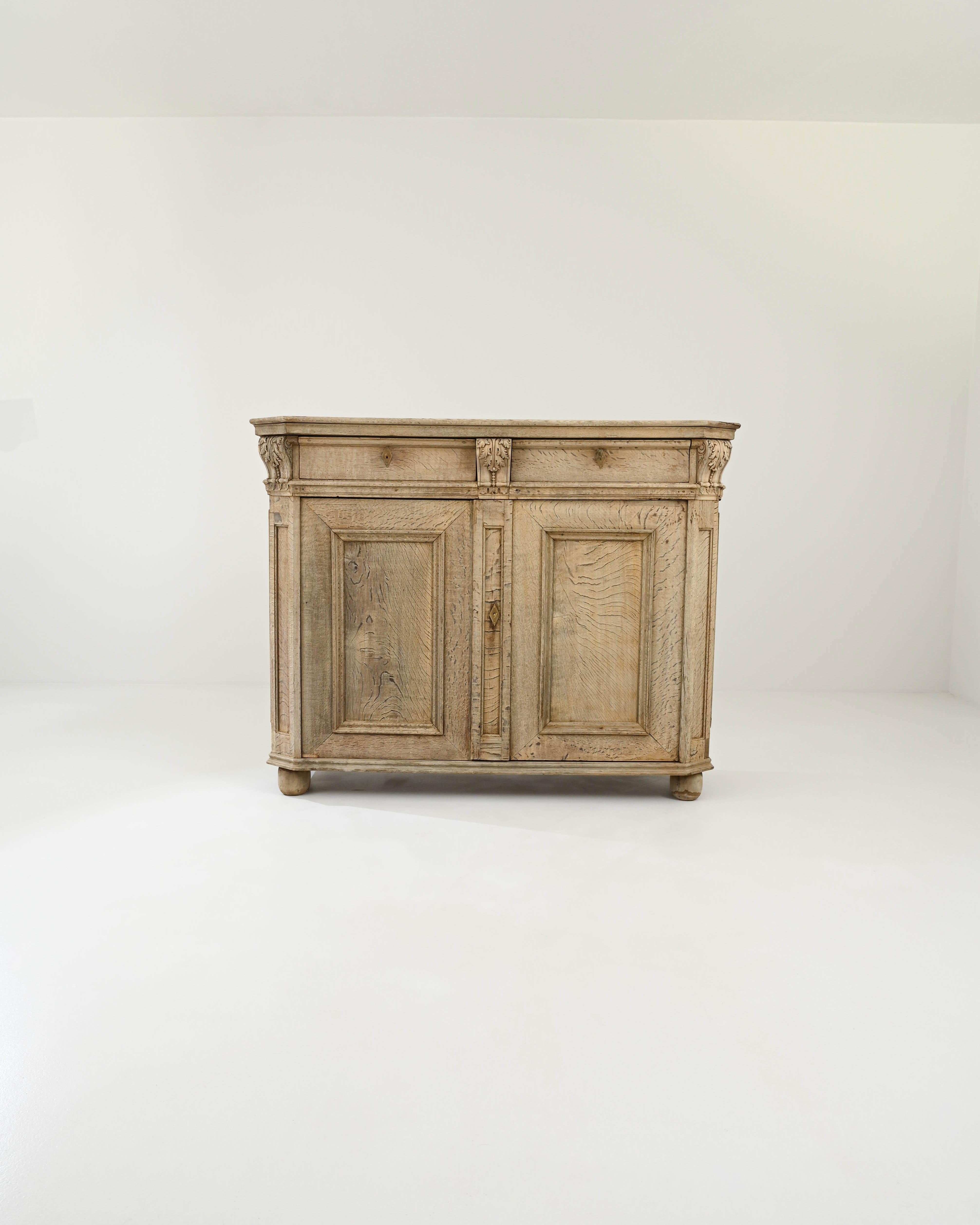 Beautiful craftsmanship and statuesque proportions give this oak buffet an air of antique grandeur. Hand-built in France in the 1800s, a brindled grain dances in dark patterns over the pale golden surface of the wood, bringing a sense of fluidity to