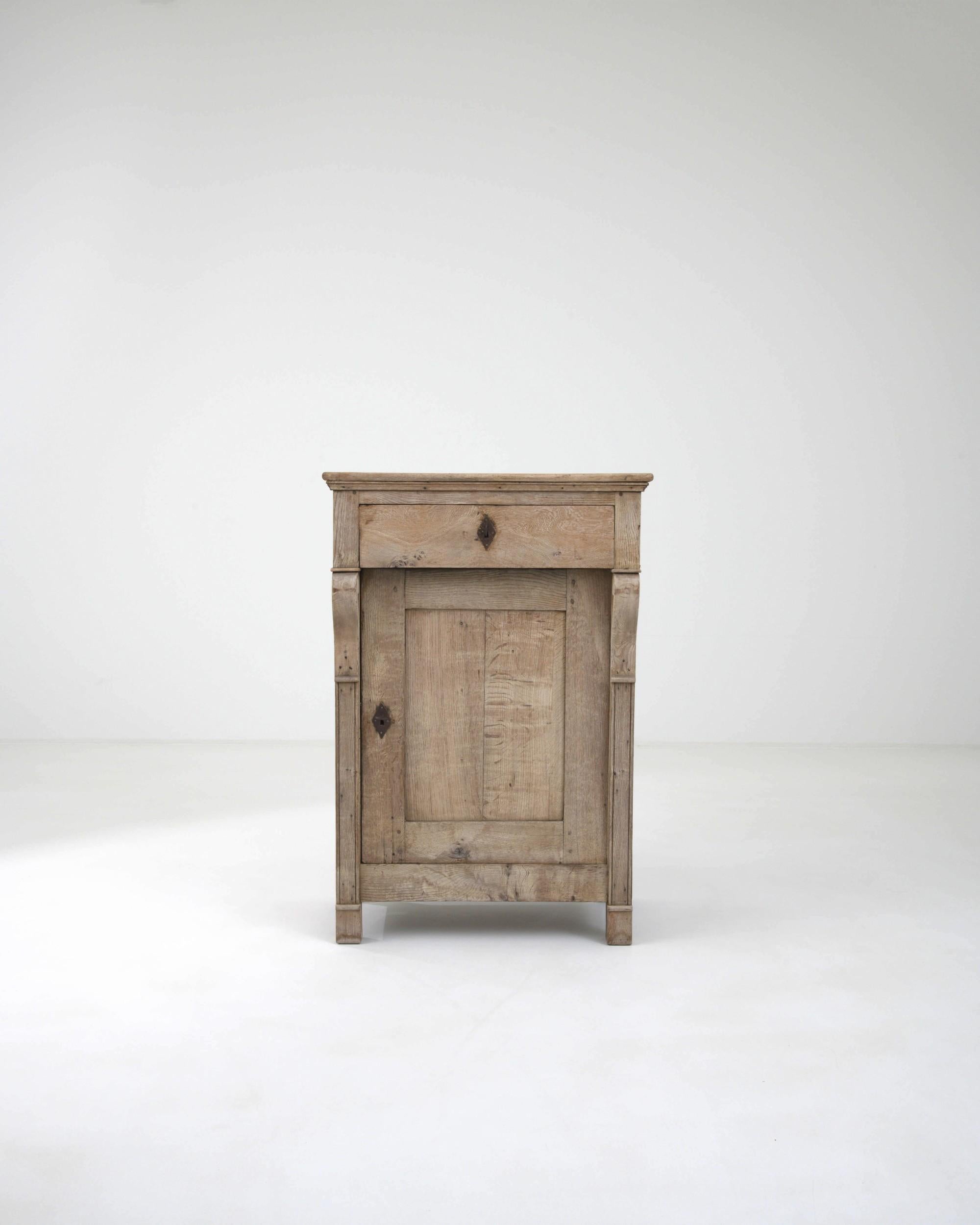 The restrained elegance and soft natural finish of this antique oak buffet creates an impression of serenity. Hand-built in France in the 1800s, the form reflects the bold, simple lines and understated majesty of Empire style. The overhang of the