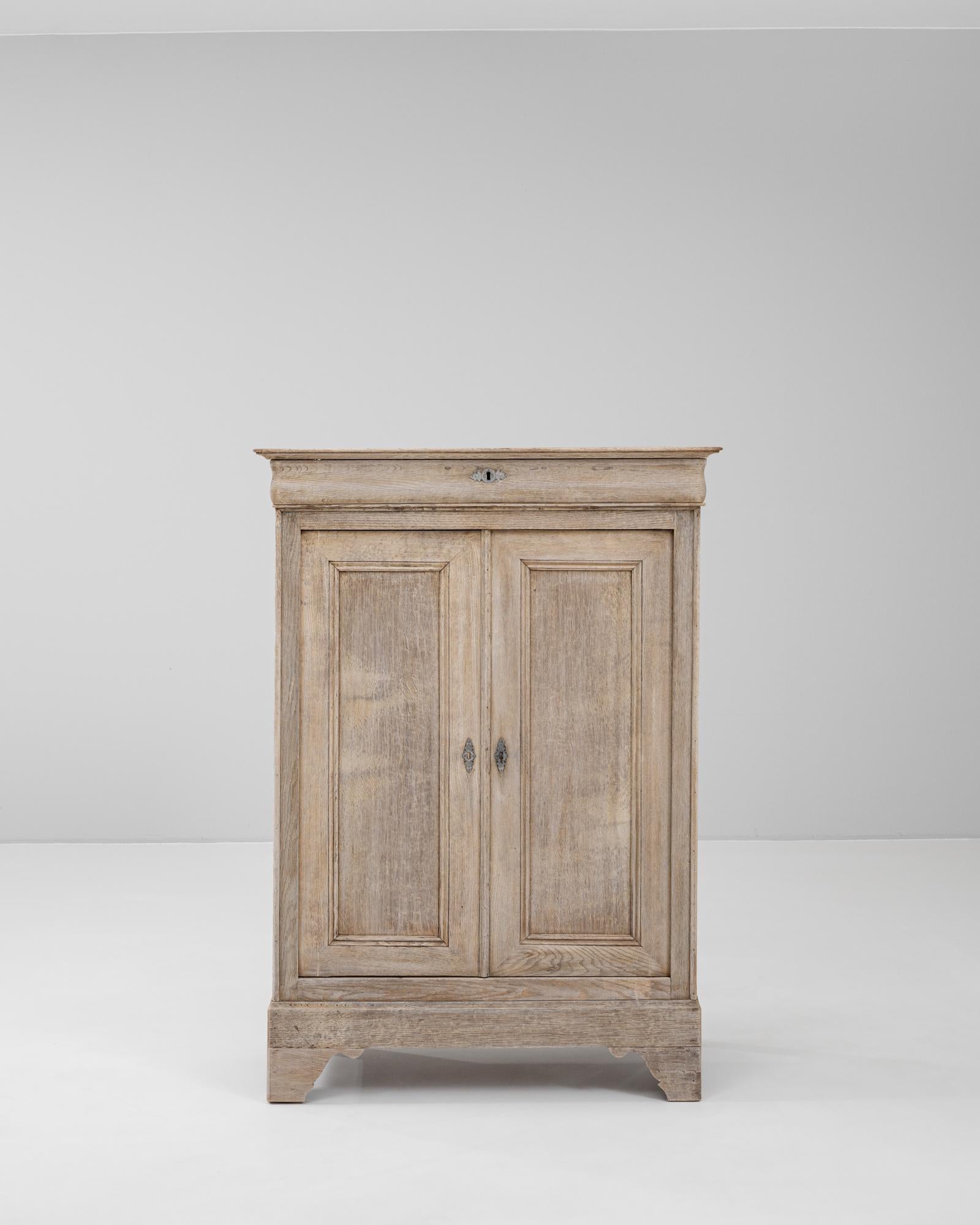 This 19th Century French oak buffet exemplifies understated elegance and fine craftsmanship from the period. Constructed from solid oak with a soft, weathered finish, the piece features a clean, rectangular form with molded panel doors and a single