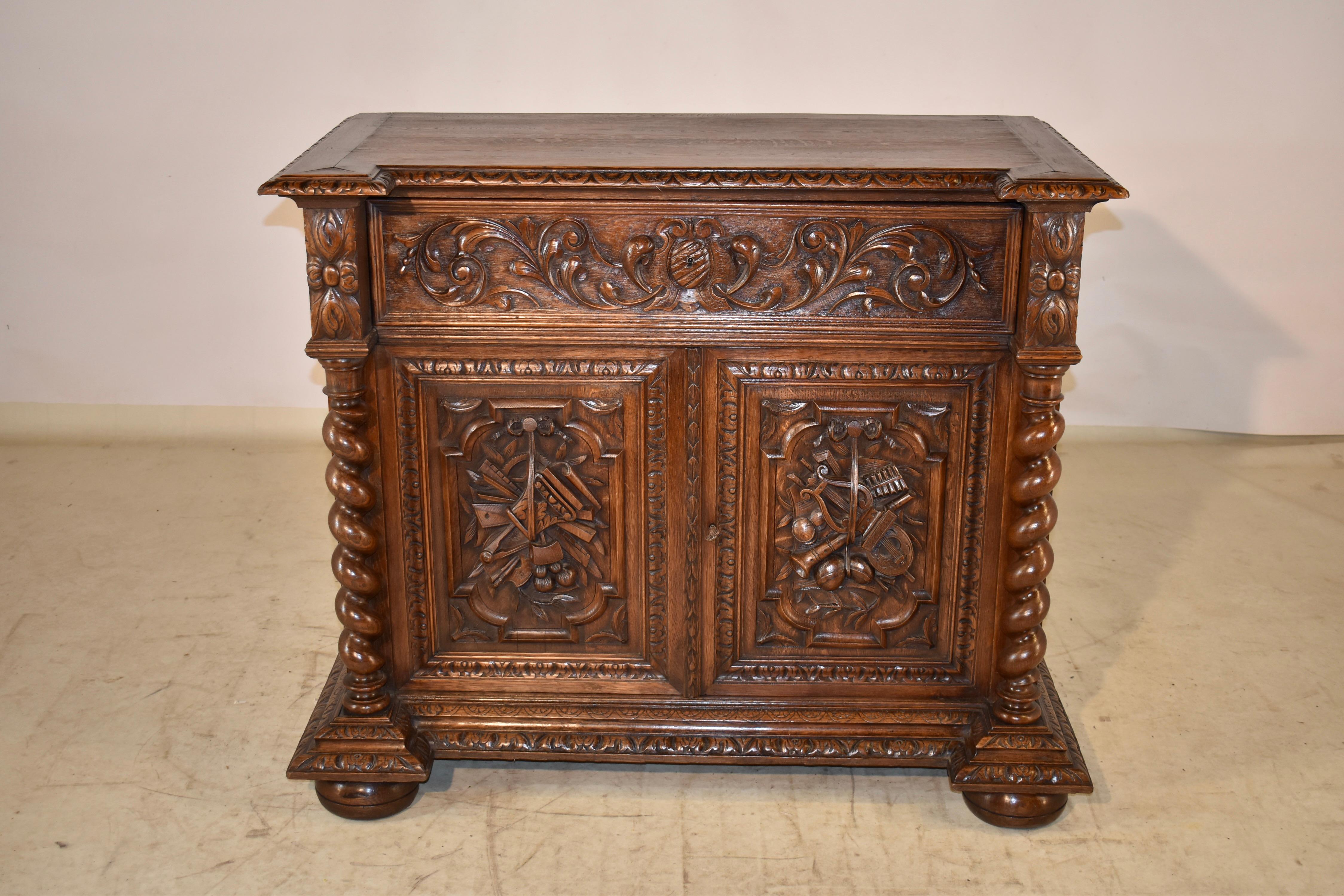 19th century oak buffet from France.  The top is banded and has a beveled and hand carved decorated edge, following down to paneled sides, which are hand carved decorated.  The front of the buffet is blocked and has a single drawer, which is paneled