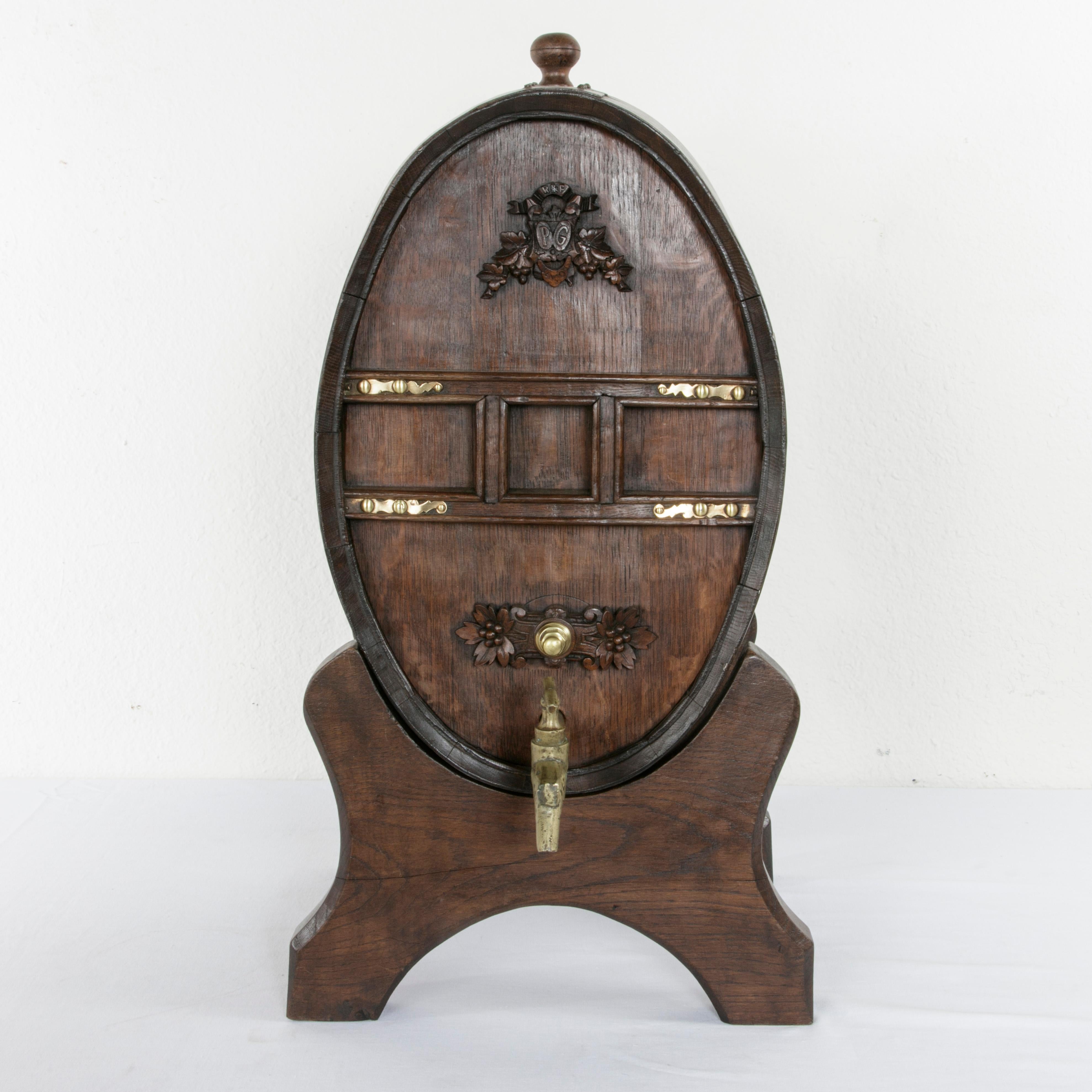 This mid-19th century artisan-made oak barrel was originally used for calvados, a regional specialty apple brandy in Normandy, France. Resting on a wooden Stand, this barrel features a hand carved cartouche and banner surrounded by grape leaves. The