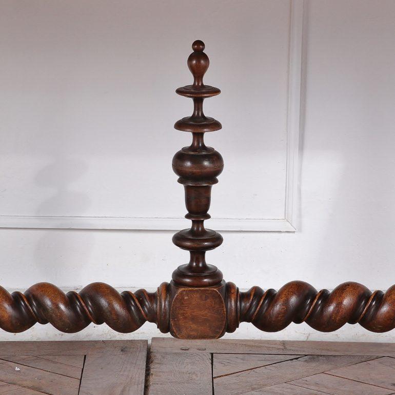 A French Renaissance-Revival oak library table featuring boldly-turned barley twist legs and a long turned stretcher which is further-decorated with large turned finials. Two panelled drawers fitted to the frieze with two corresponding false drawers