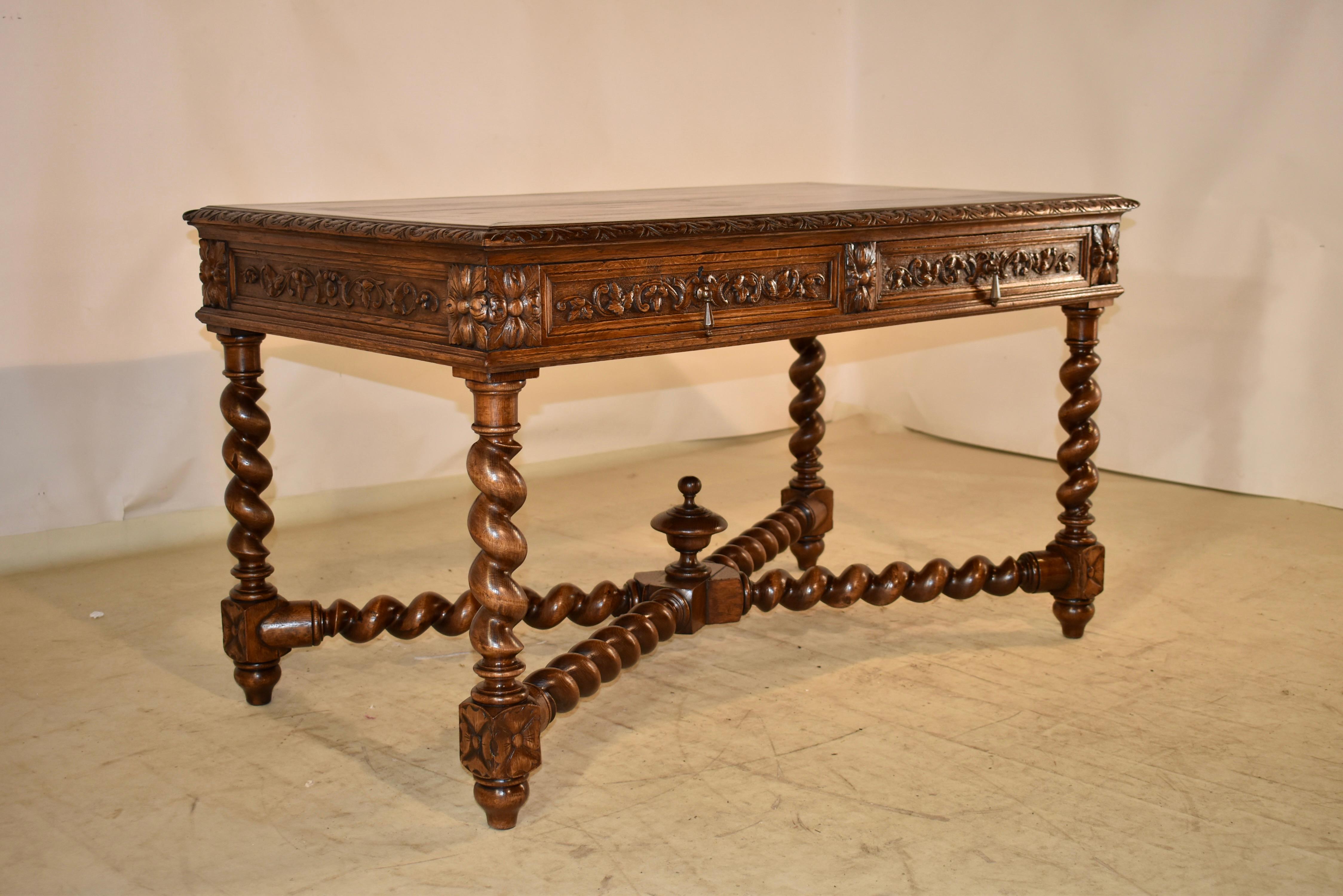 19th century oak desk from France.  The top is beautifully grained and has banding.  The top is finished with a beveled and carved edge.  The apron is paneled and hand carved decorated on all four sides, for easy placement in any room.  In the front