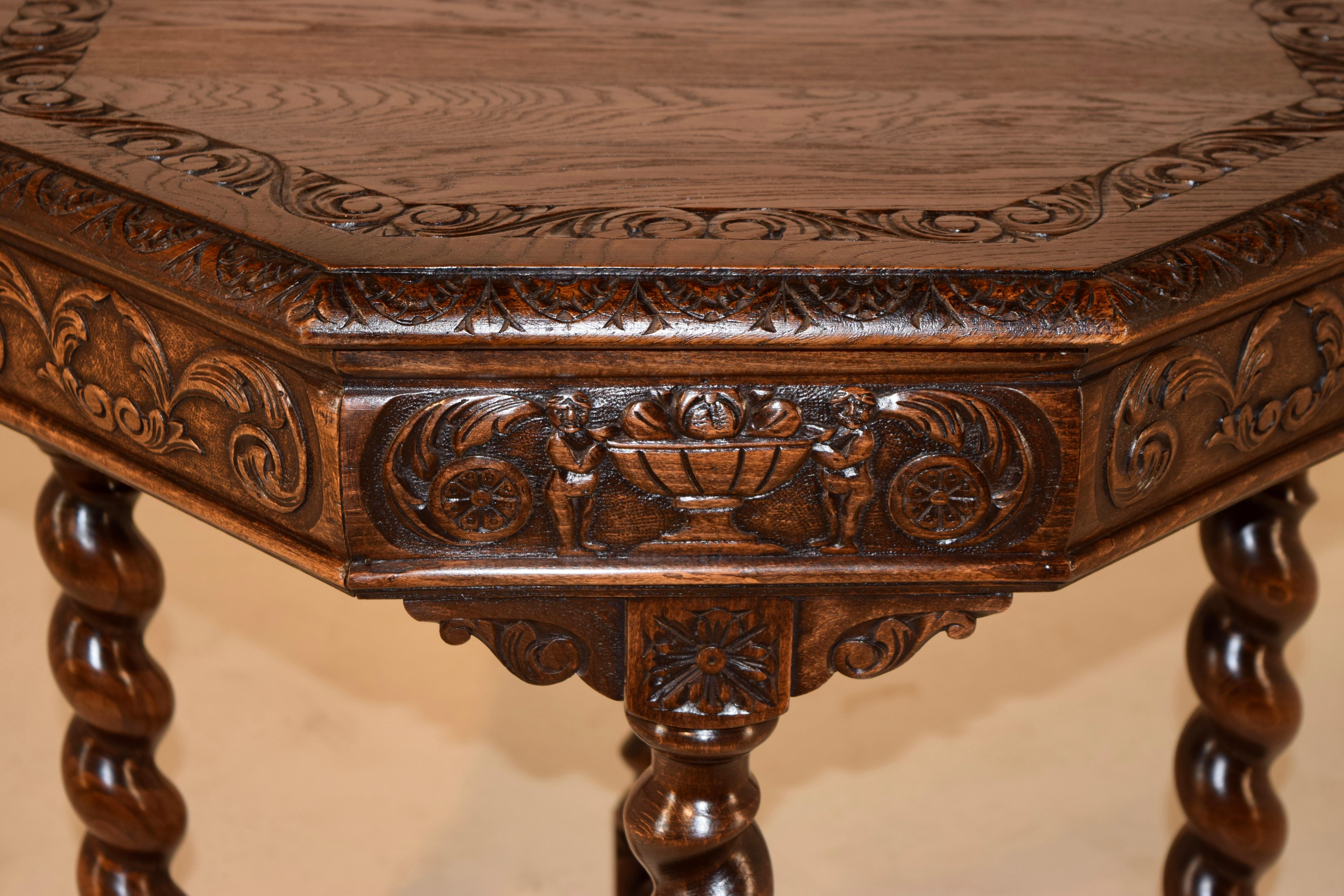 19th Century oak side table from France with carved decorated banding on the top, surrounded by a beveled and hand carved edge. This follows down to a hand carved apron with carved urns and acanthus leaf carvings, over hand turned barley twist legs,