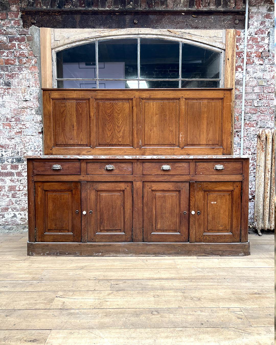 Questa elegante credenza francese del XIX secolo proviene da un castello e mostra l'artigianato tipico di quel periodo. Realizzata in rovere massiccio con una ricca patina, la parte inferiore presenta quattro ante a pannelli e quattro cassetti,
