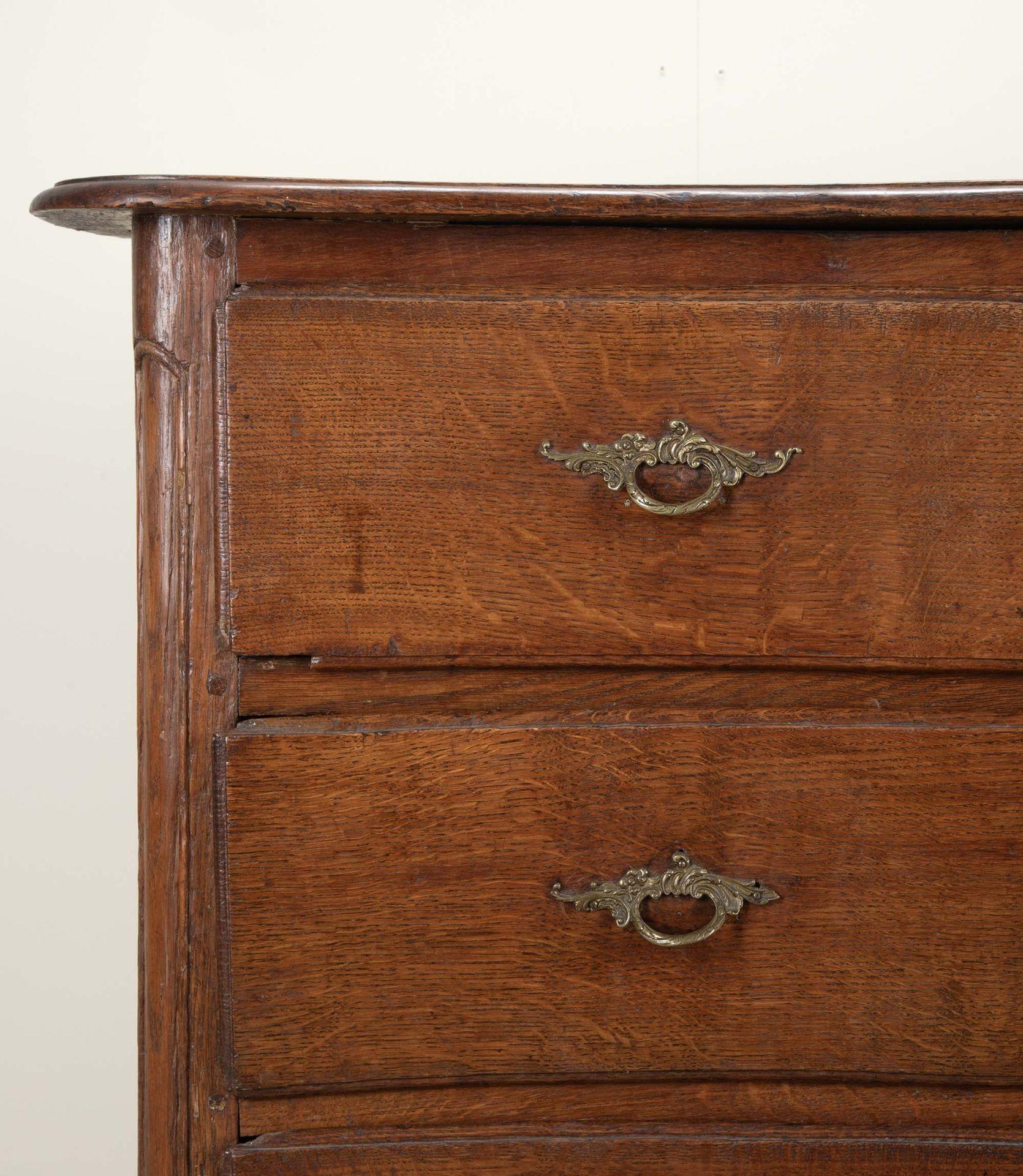 19th Century French Provincial oak commode. 
With a serpentine front and retaining it's original handles.
