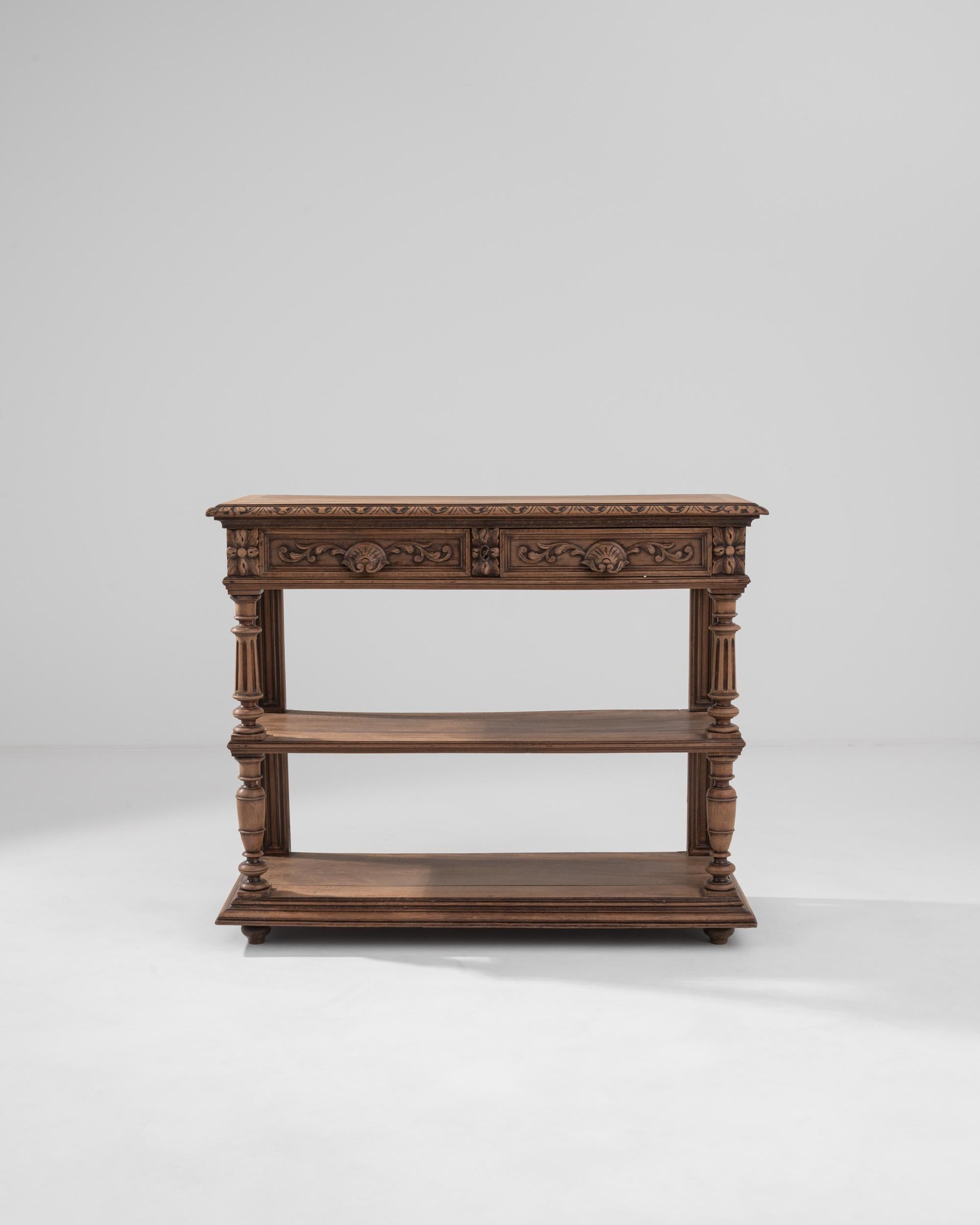 This oak console table was made in 19th century France. The top of this intriguing piece folds up to reveal a desktop and gallery; and its undercover identity as a moonlight writing table. Eye-catching carved motifs line the edge of the table top,
