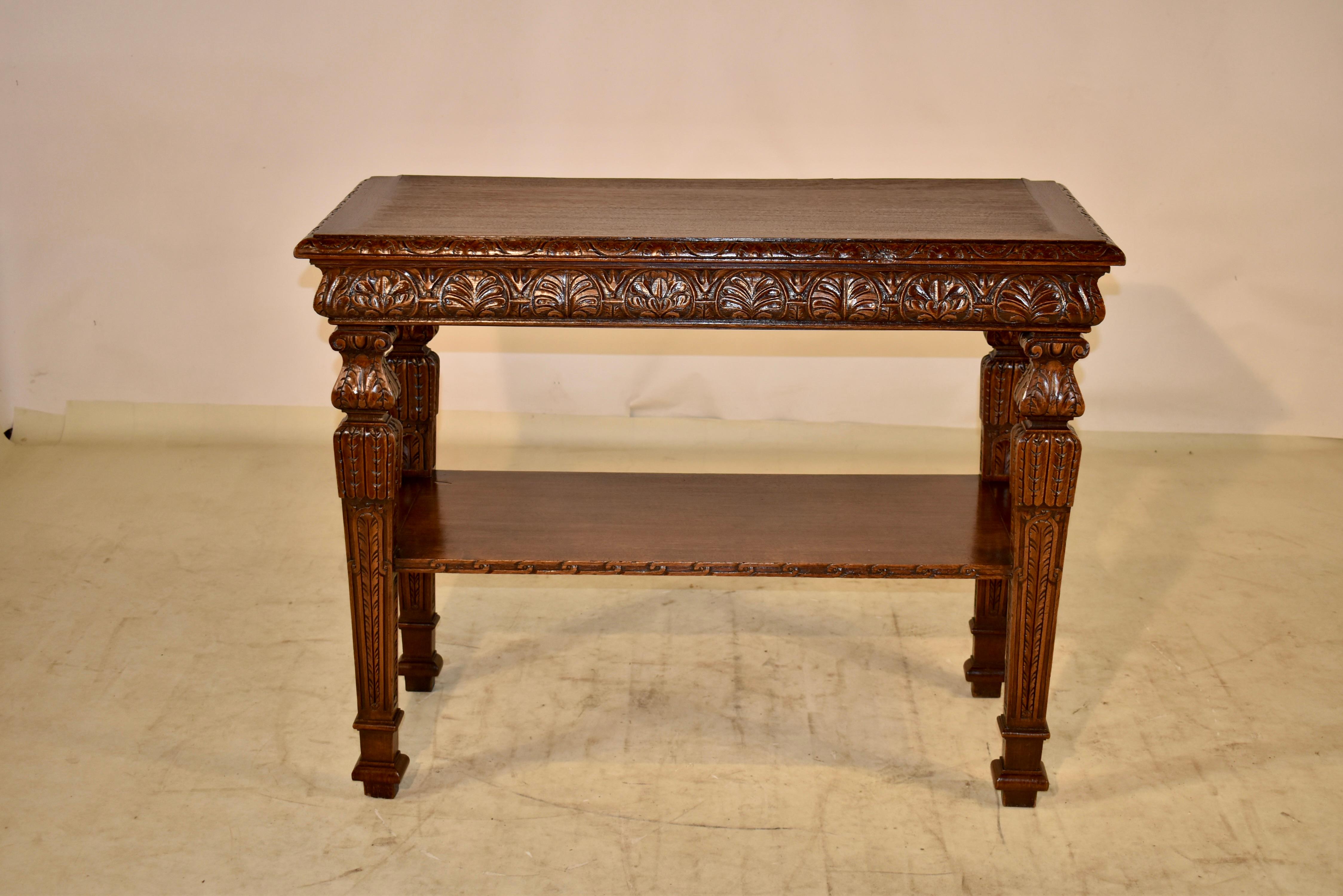 19th century oak console table from France with a beveled and hand carved decorated edge, following down to a lovely hand carved and molded shaped apron.  The table is supported on hand shaped and carved decorated legs, which are joined by a lower
