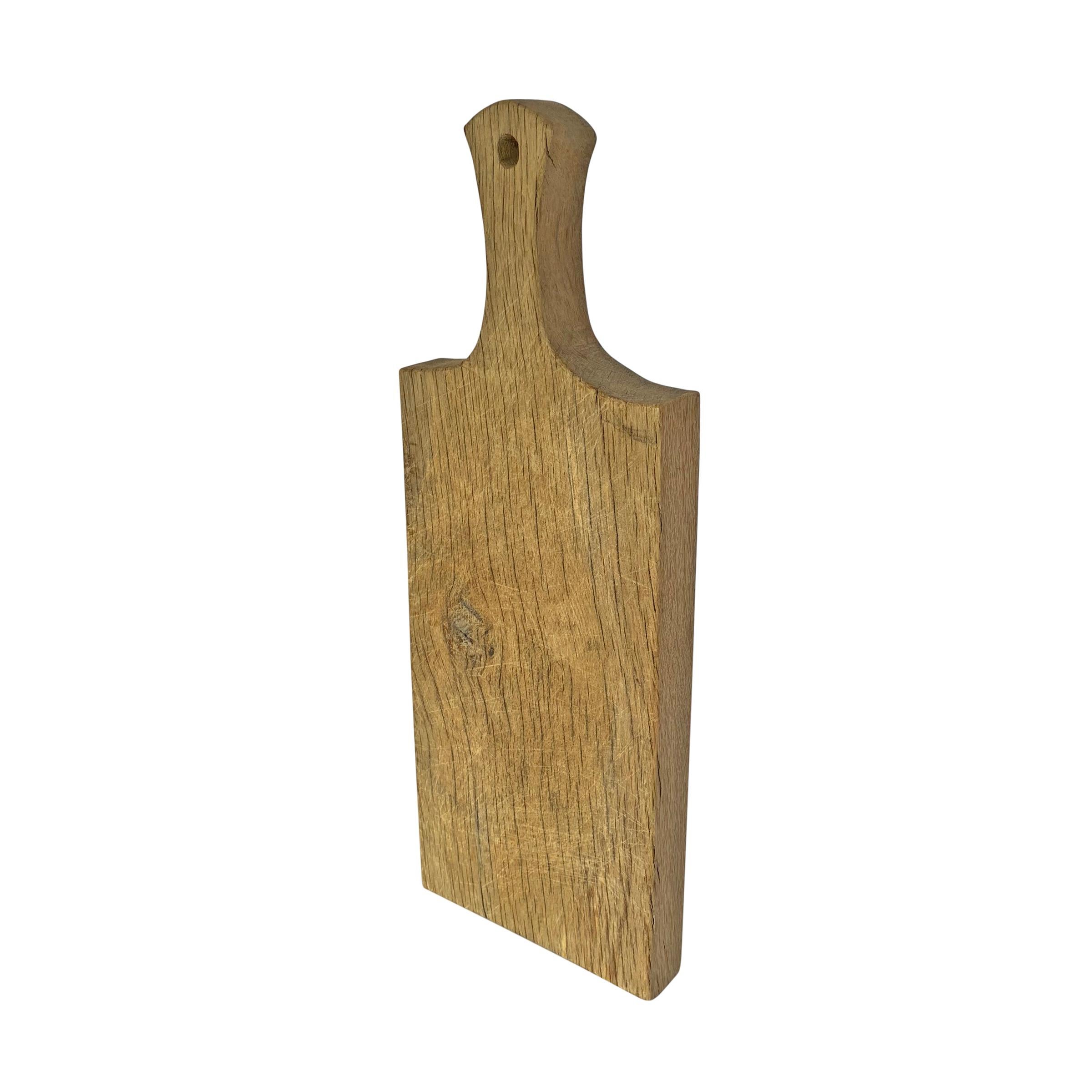 A late 19th century French oak cutting board with a sturdy demeanor, a wonderful golden color, and a hole for hanging. Perfect for charcuterie or cheese!