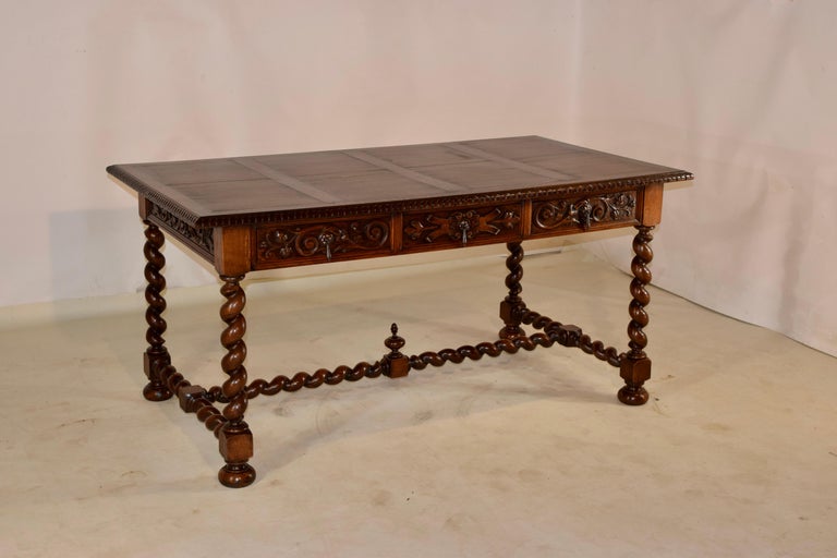 19th century oak desk from France with a lovely and interesting hand paneled top, which is also banded around the edges to hinder shrinkage. The top is finished with a beveled and carved decorated edge, following down to hand carved and paneled