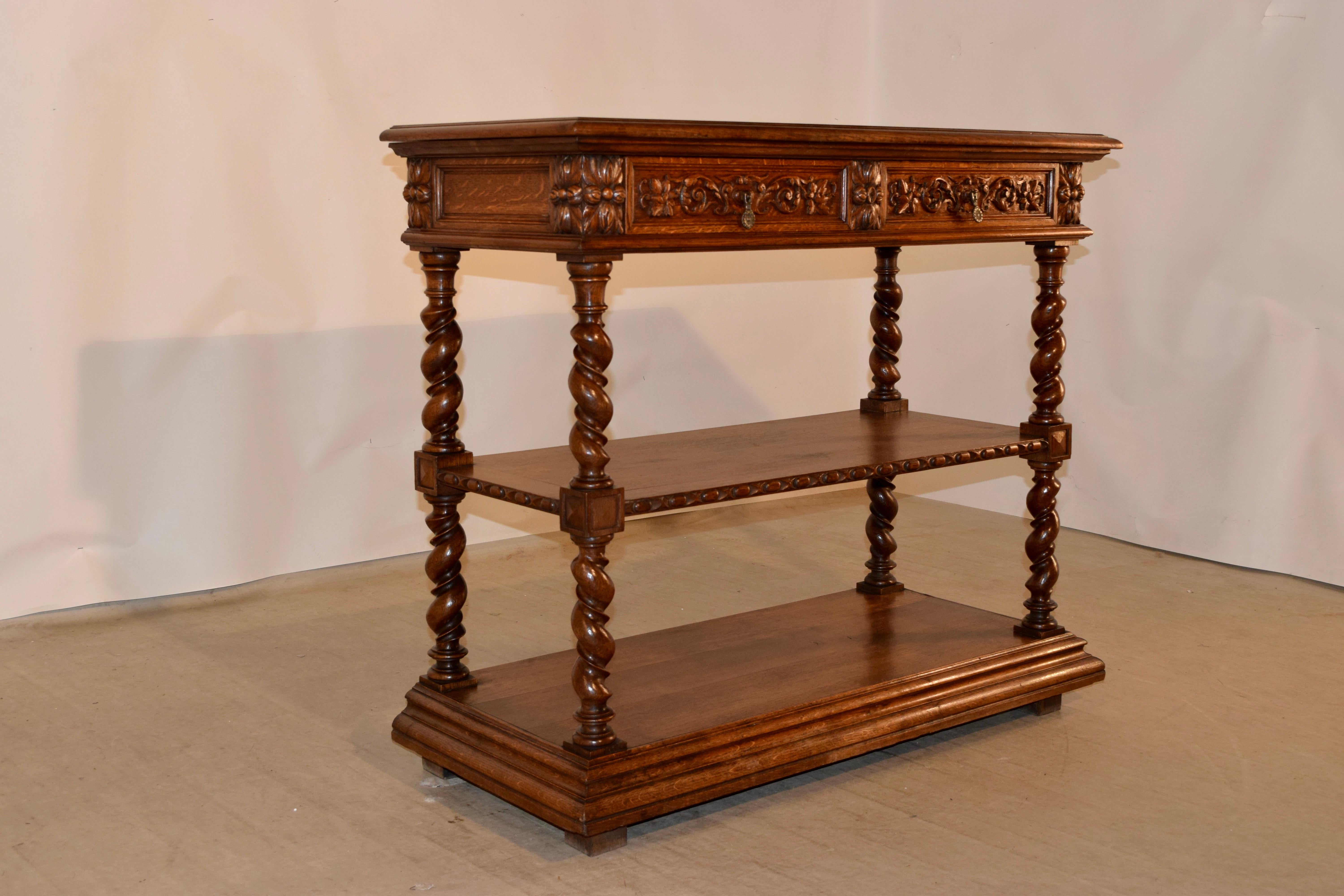 19th century oak dessert buffet from France with a beveled edge around the top, which opens to reveal a marble serving surface over two drawers with hand carved decorated drawer fronts and paneled sides. The legs are hand turned vine twist and have