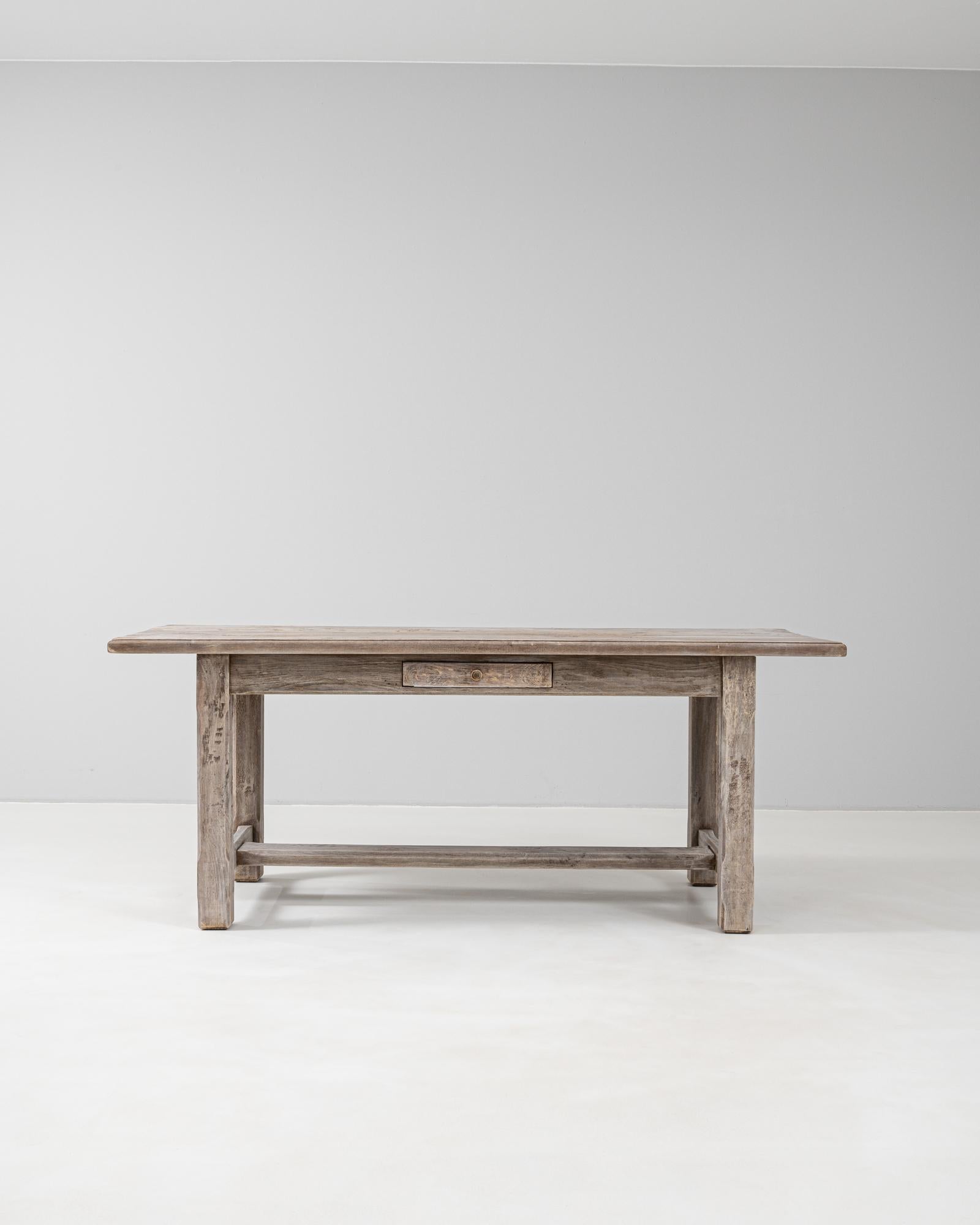 This 19th Century French oak dining table showcases the beauty of simplicity with its clean lines, rustic finish, and utilitarian charm. Crafted from solid oak, the table features a long rectangular top with softly rounded edges and visible grain