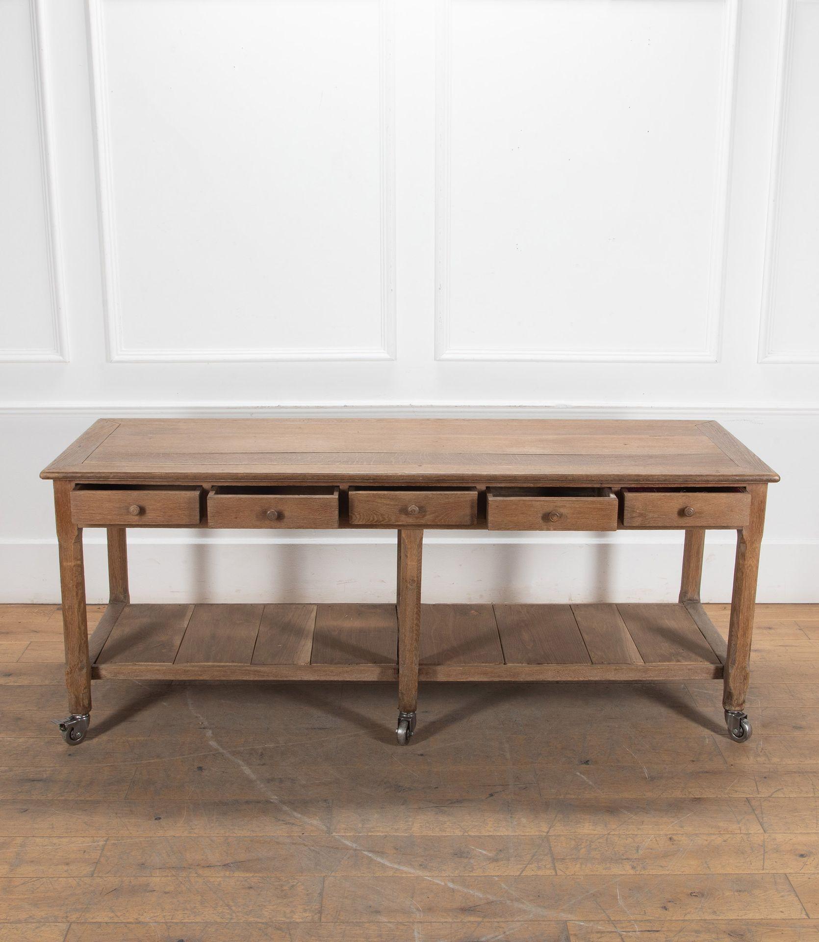 Large late 19th Century French oak drapers or kitchen prep table.
With ten drawers and storage shelf.
Lovely original mellow patina.
The table has been raised on later industrial castors, two with brakes to steady the table.
Circa 1880.