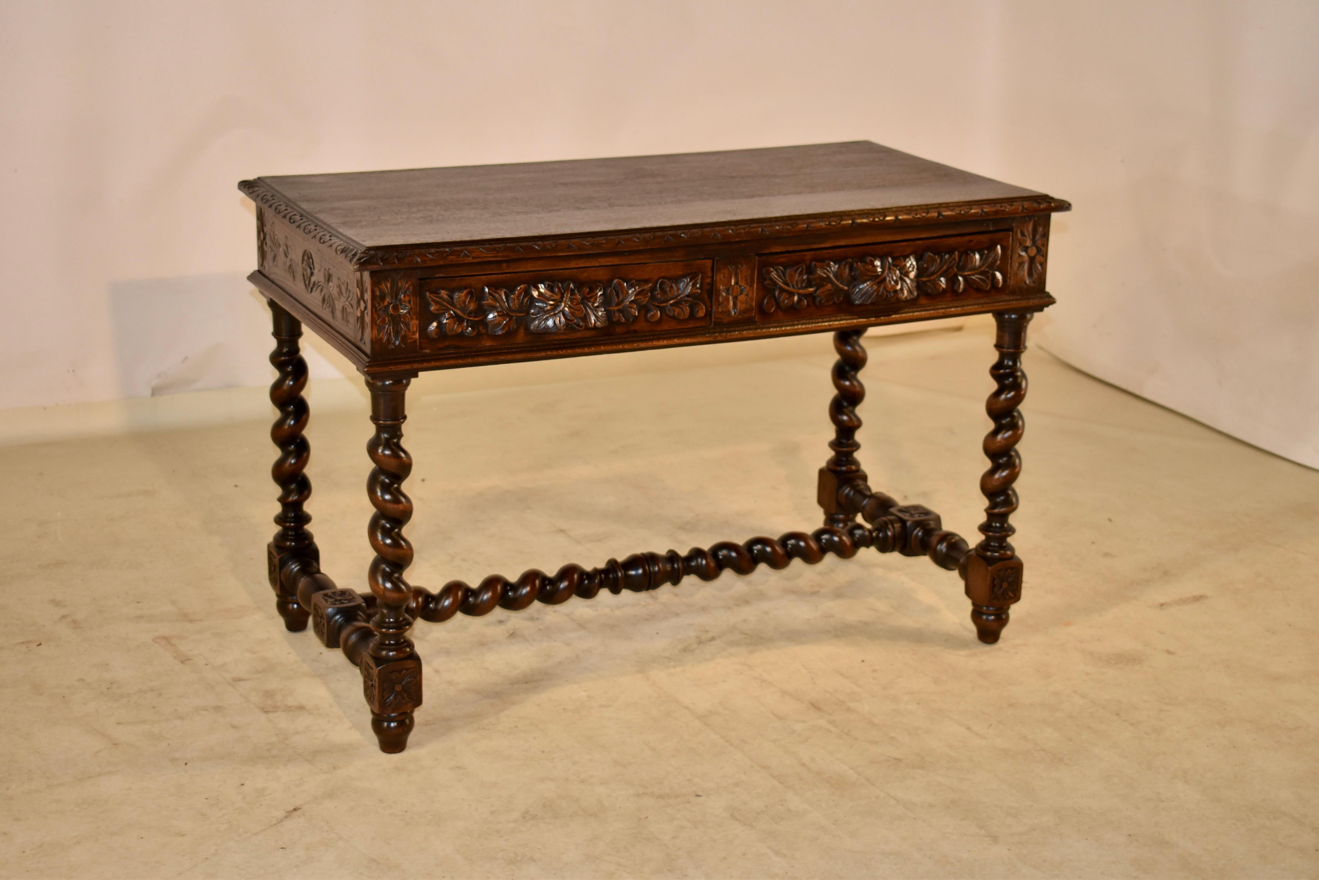 19th century oak library table from France. The top has a lovely hand beveled and carved decorated edge, and follows down to carved decorated sides and a finished back for easy placement in any room. The front contains two drawers, both with lovely