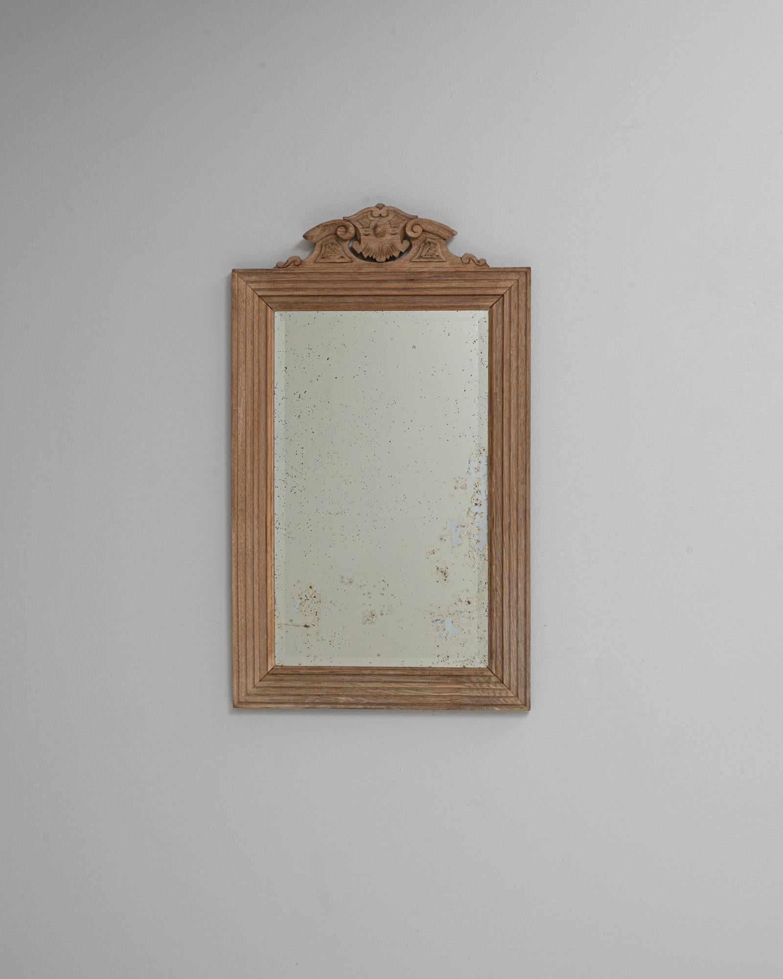 Specchio in quercia francese del XIX secolo con raffinati dettagli intagliati e una silhouette tranquillamente elegante. La cornice rettangolare è realizzata in quercia patinata al naturale e le sue modanature lineari sottolineano la chiarezza e la