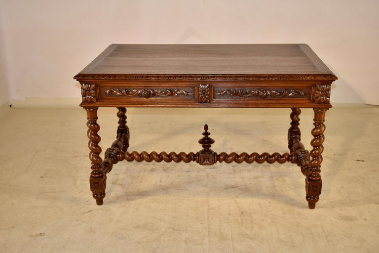 19th century French oak partner's desk with a banded top, which has a beveled and hand carved decorated edge as well. The top follows down to three hand paneled sides and two drawers on each side. The drawers on the front side are hand paneled and