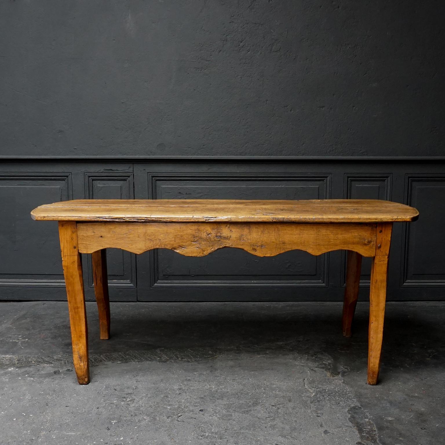 An antique French Provincial low oak farmhouse kitchen table with a nice rustic used surface above a scalloped apron edge on cabriole shaped legs.
As you can see the tabletop has plenty of heavily used character including two very decorative holes
