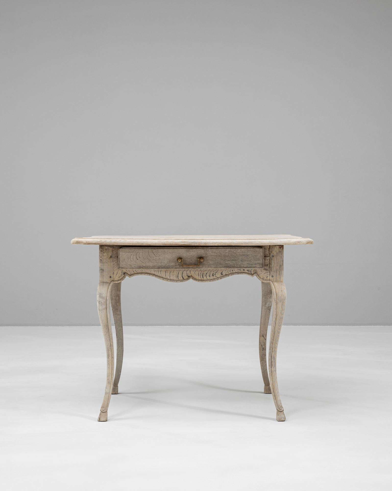 This elegant 19th century French oak side table brings a touch of classic European charm to any space. Crafted from solid oak, the table features gracefully curved cabriole legs and a subtly scalloped apron, showcasing the refined craftsmanship