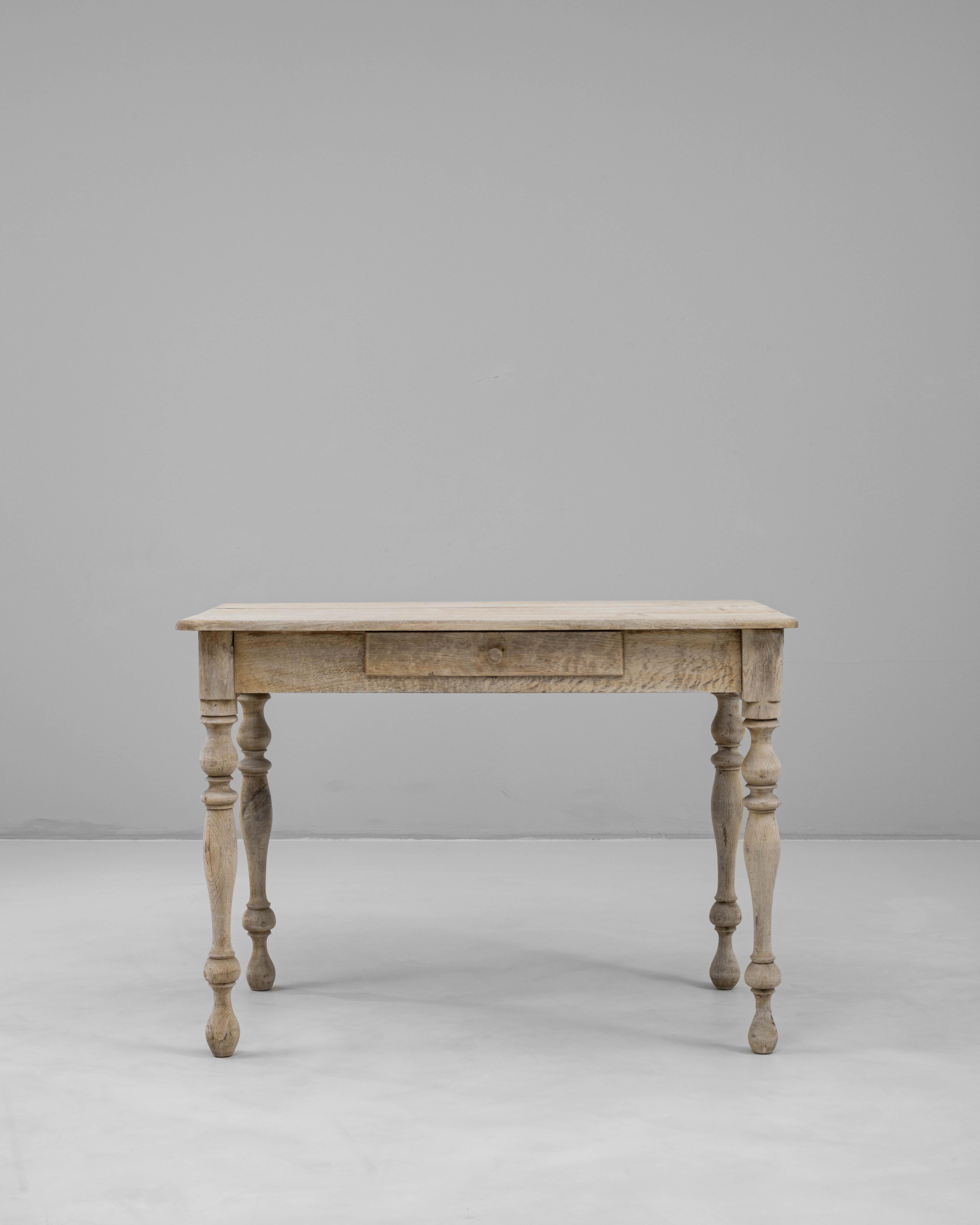 A charming 19th-century side table crafted in France from solid oak. This piece features turned legs, a subtle patina, and a single drawer for discreet storage. Its balanced proportions and traditional joinery highlight its timeless craftsmanship,