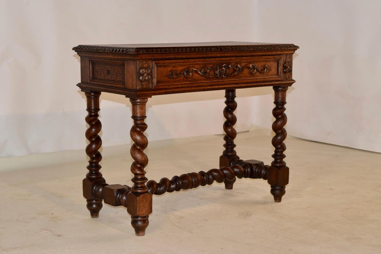 19th century oak side table from France with a banded top and a beveled and carved decorated edge. The apron is paneled and carved decorated on all four sides for easy placement in any room. There is a single drawer in the front with hand carved