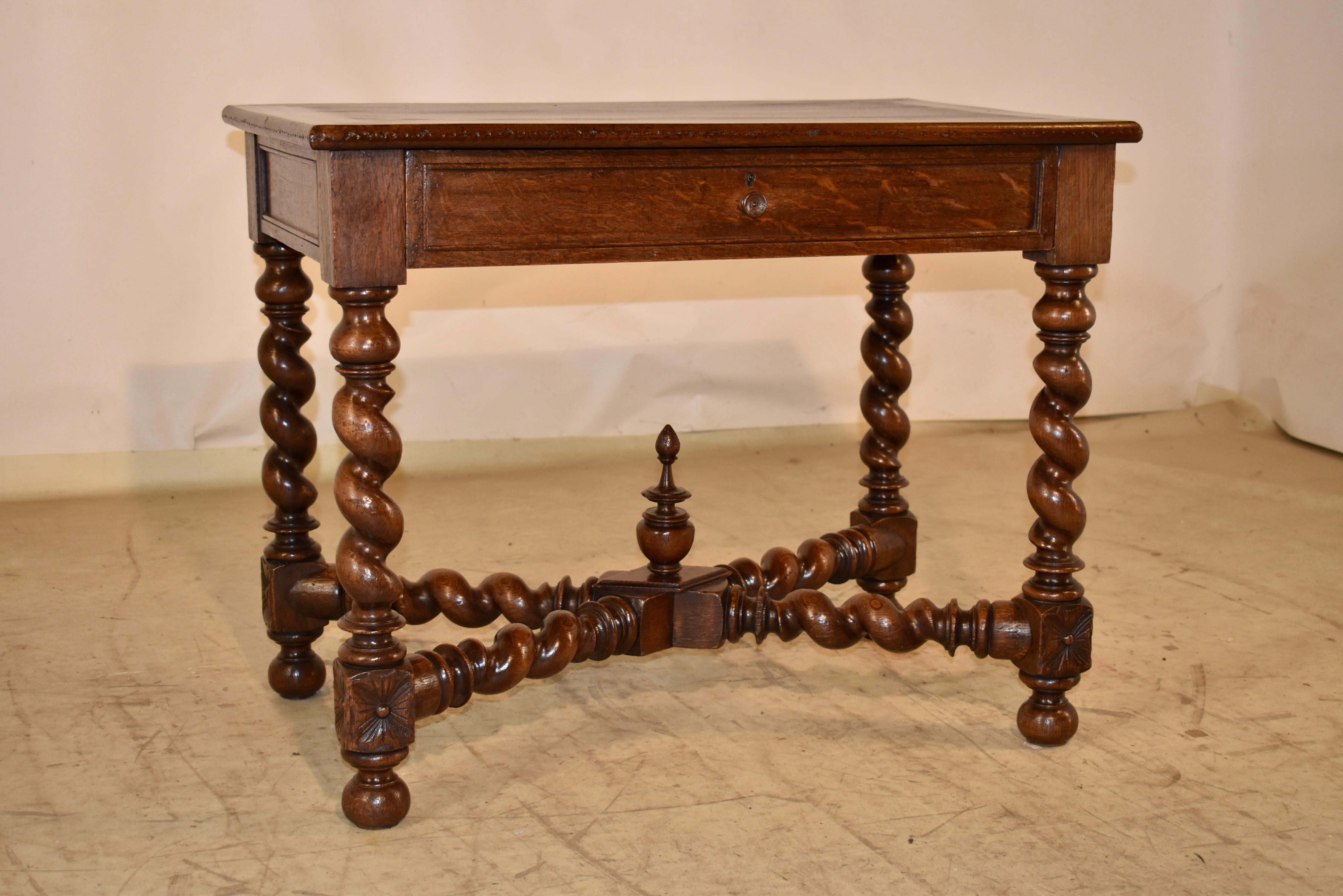 Mesa auxiliar de roble del siglo XIX, procedente de Francia.  La encimera tiene un bonito veteado, que sigue hasta los laterales panelados y un único cajón en la parte delantera. 
La mesa se apoya en patas torneadas a mano, unidas por travesaños