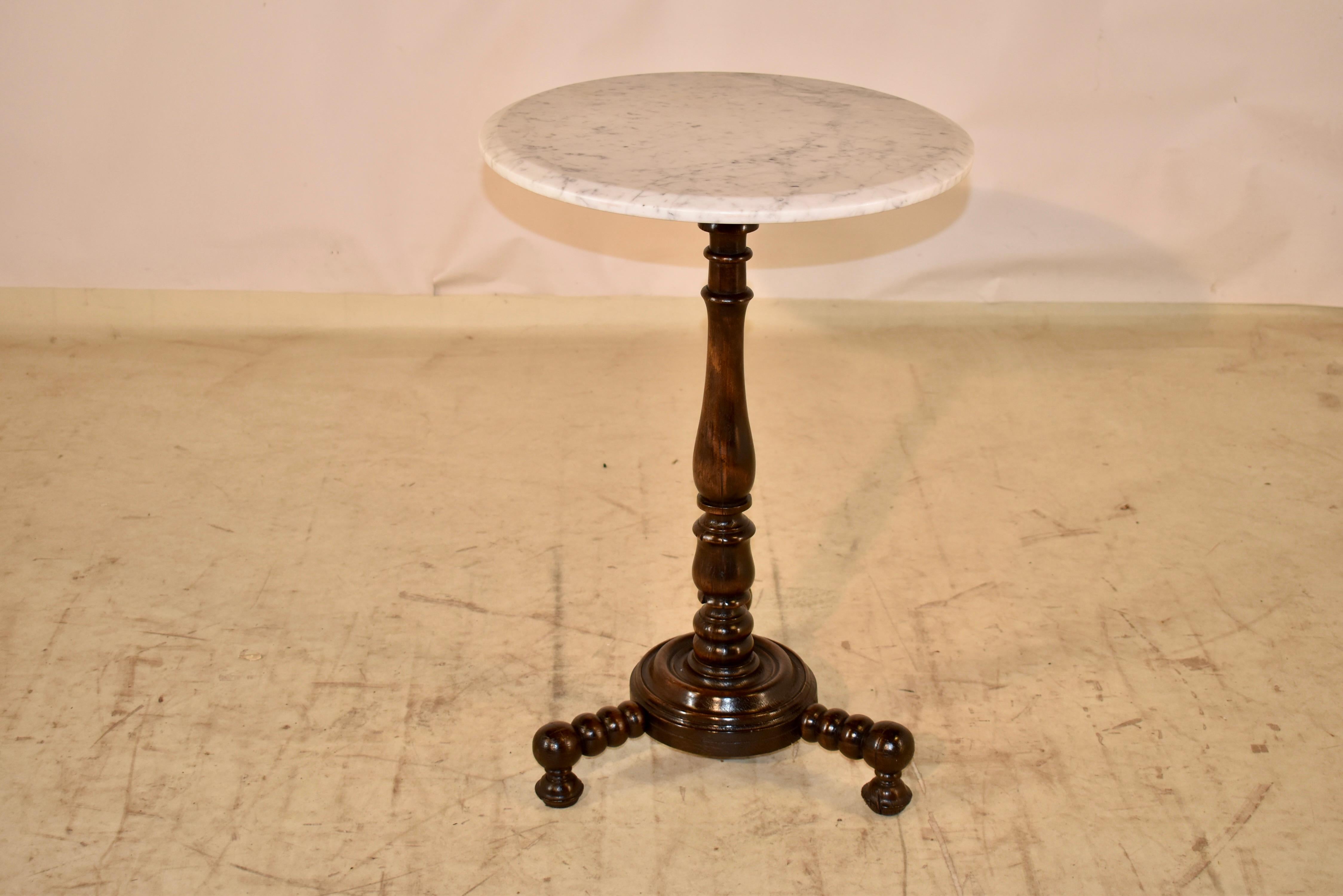 19th century oak side table from France.  The top is made from Carrara marble and it sits upon a hand turned oak base.  The base has a central hand turned pedestal, supported on a richly turned base, which has three spool turned legs.  The legs are