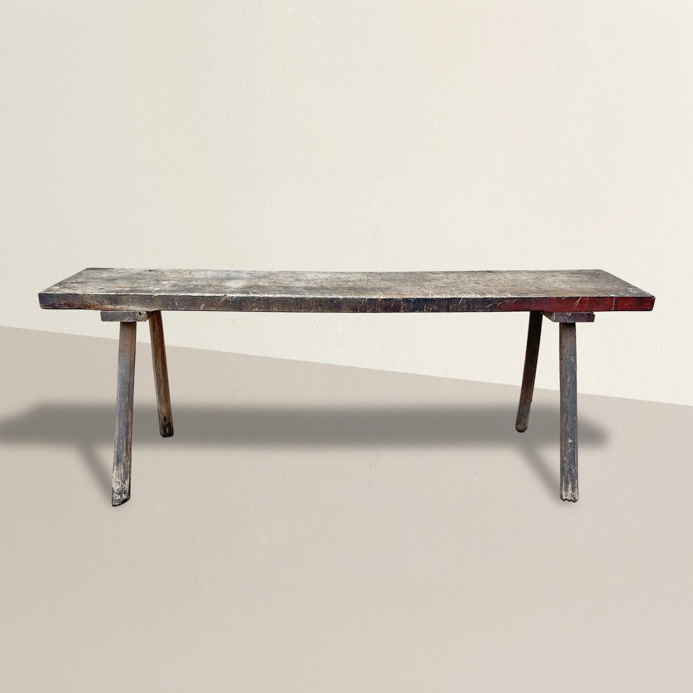 Une incroyable table en chêne français du 19e siècle, de construction simple, avec des pieds évasés et des centaines de marques de découpe sur le plateau qui témoignent de son utilisation originale comme table de boucher. La table console, la table