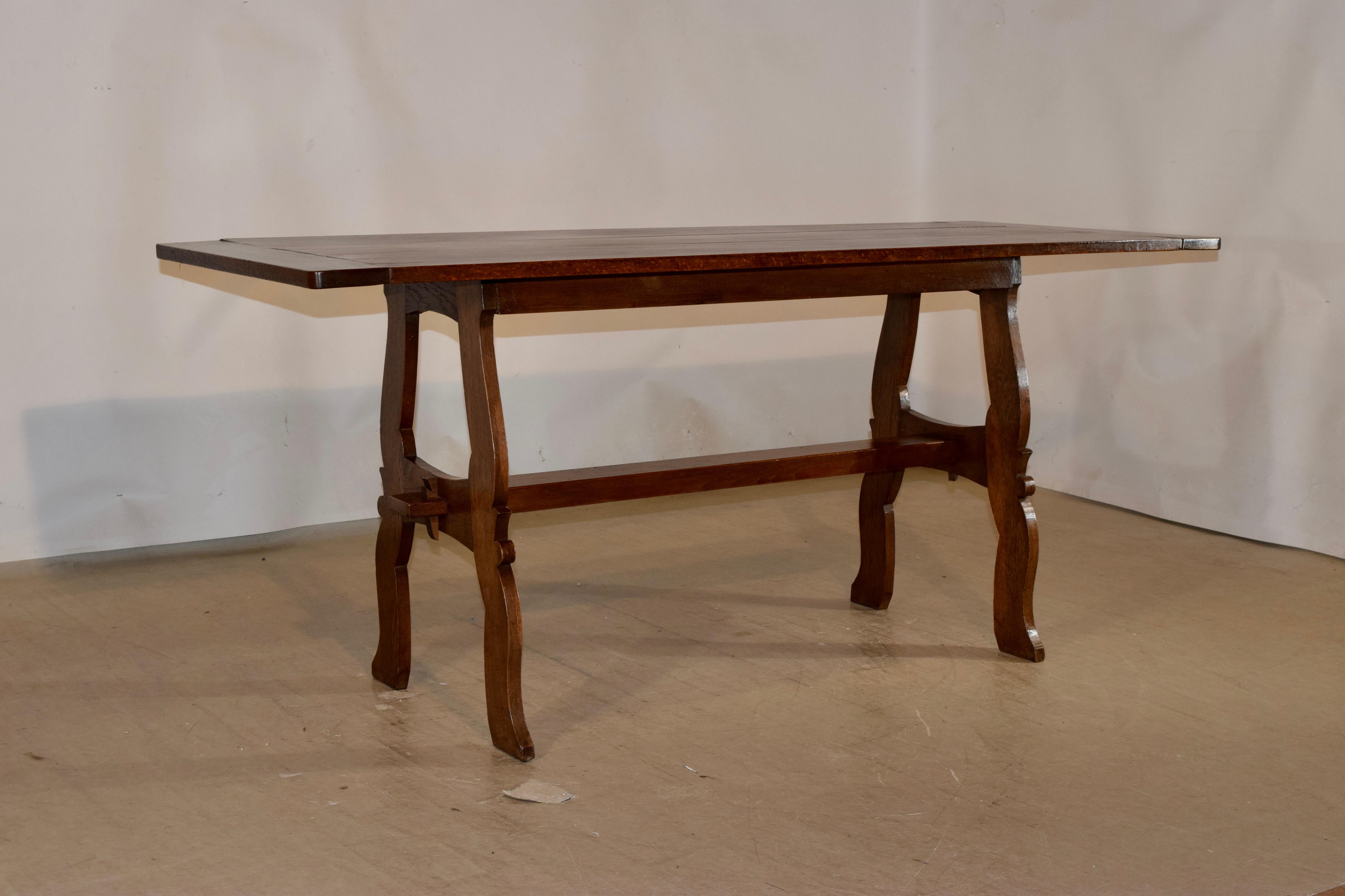 Late 19th century oak table from France with a three board top which has banded ends, supported on a very simple apron and supported on scalloped legs, joined by a simple stretcher. Gorgeous in its simplicity.