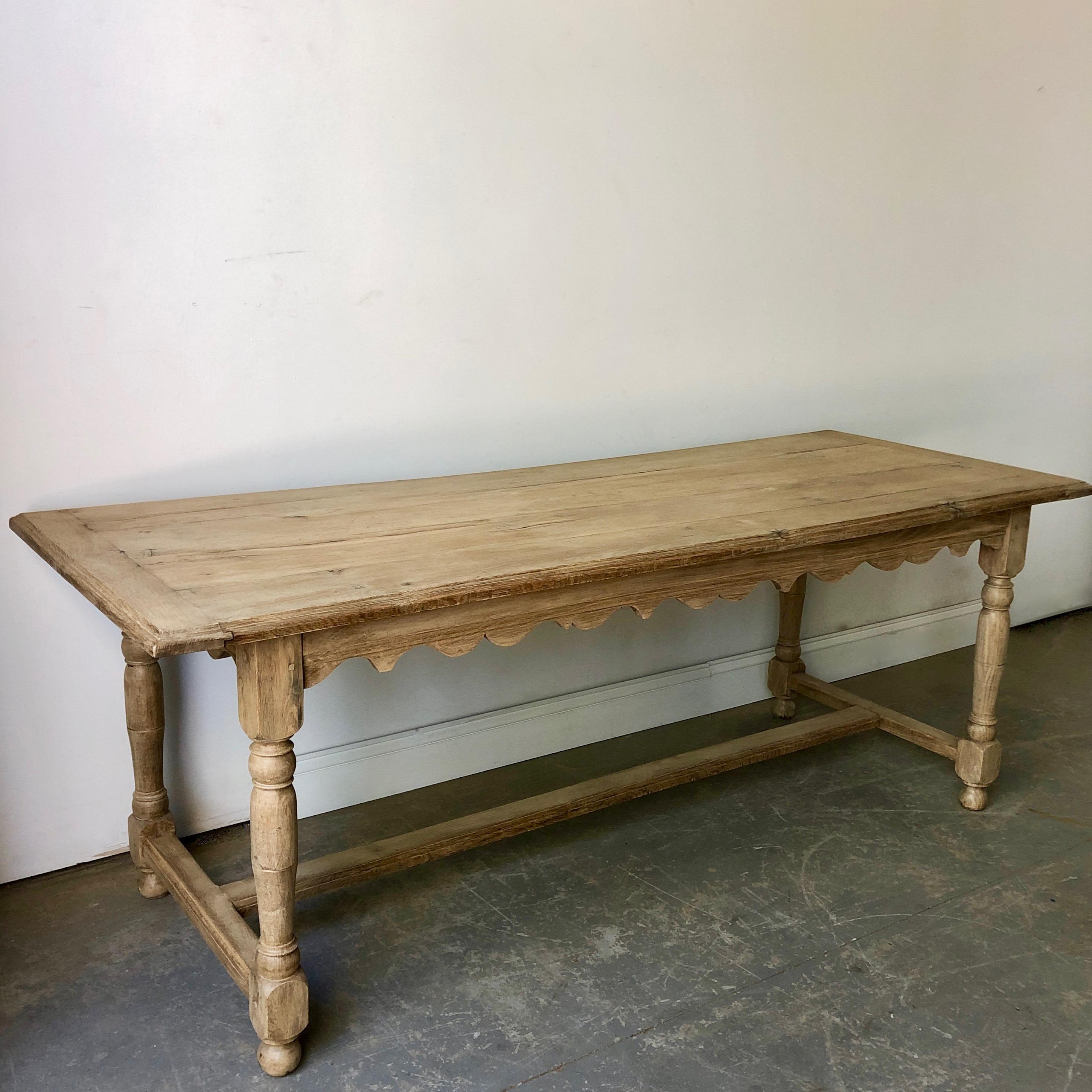 19th century French blond oak table with charming scallopped apron, baluster colums and strecher -- supporded on ball feet.

 
