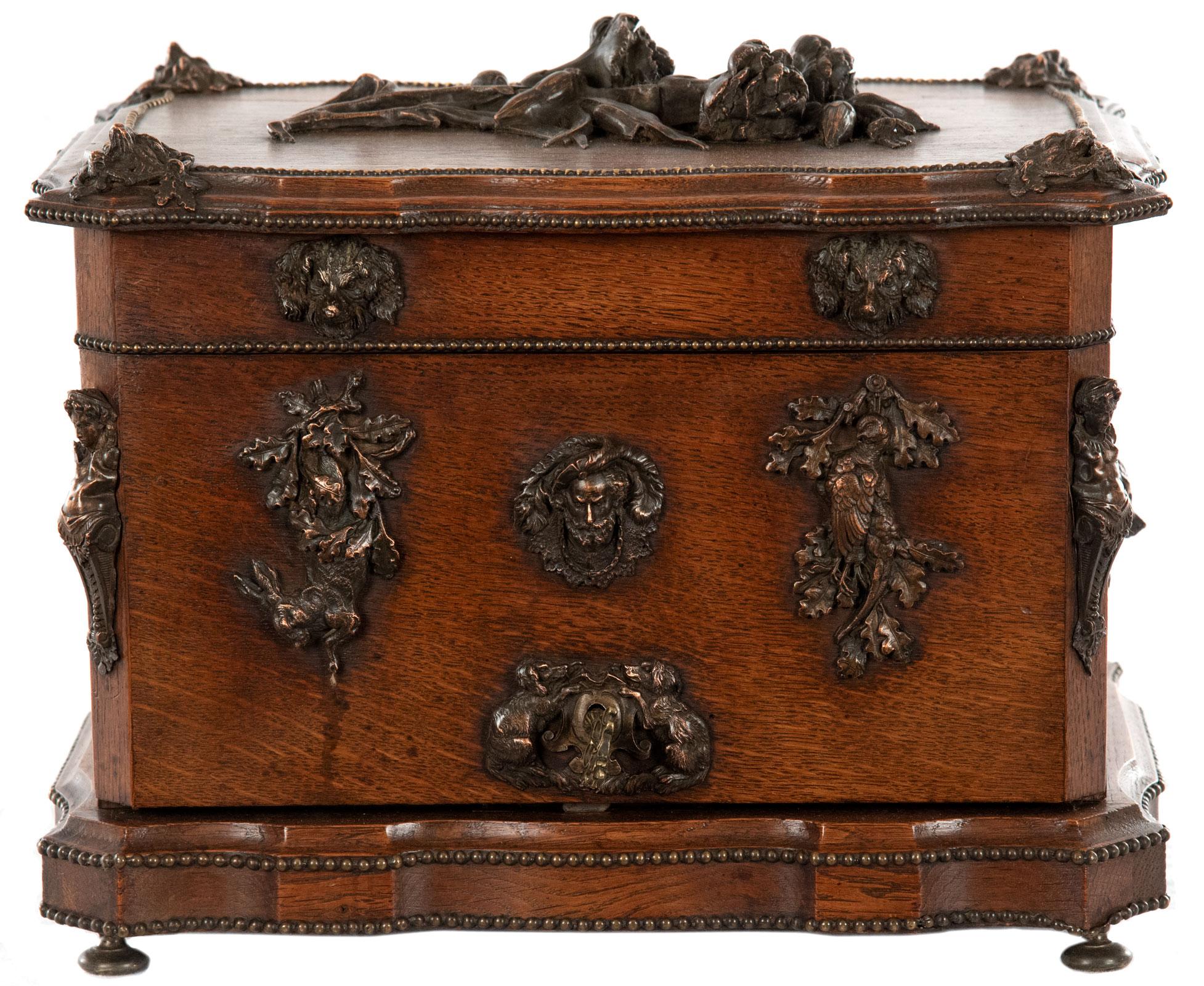 A mid-19th century French oak box tantalus with a locking, self-folding front and folding sides that open to reveal an interior fitted with a gilt bronze and oak caddy that holds sixteen crystal pieces of stemware and four decanters with stops. The