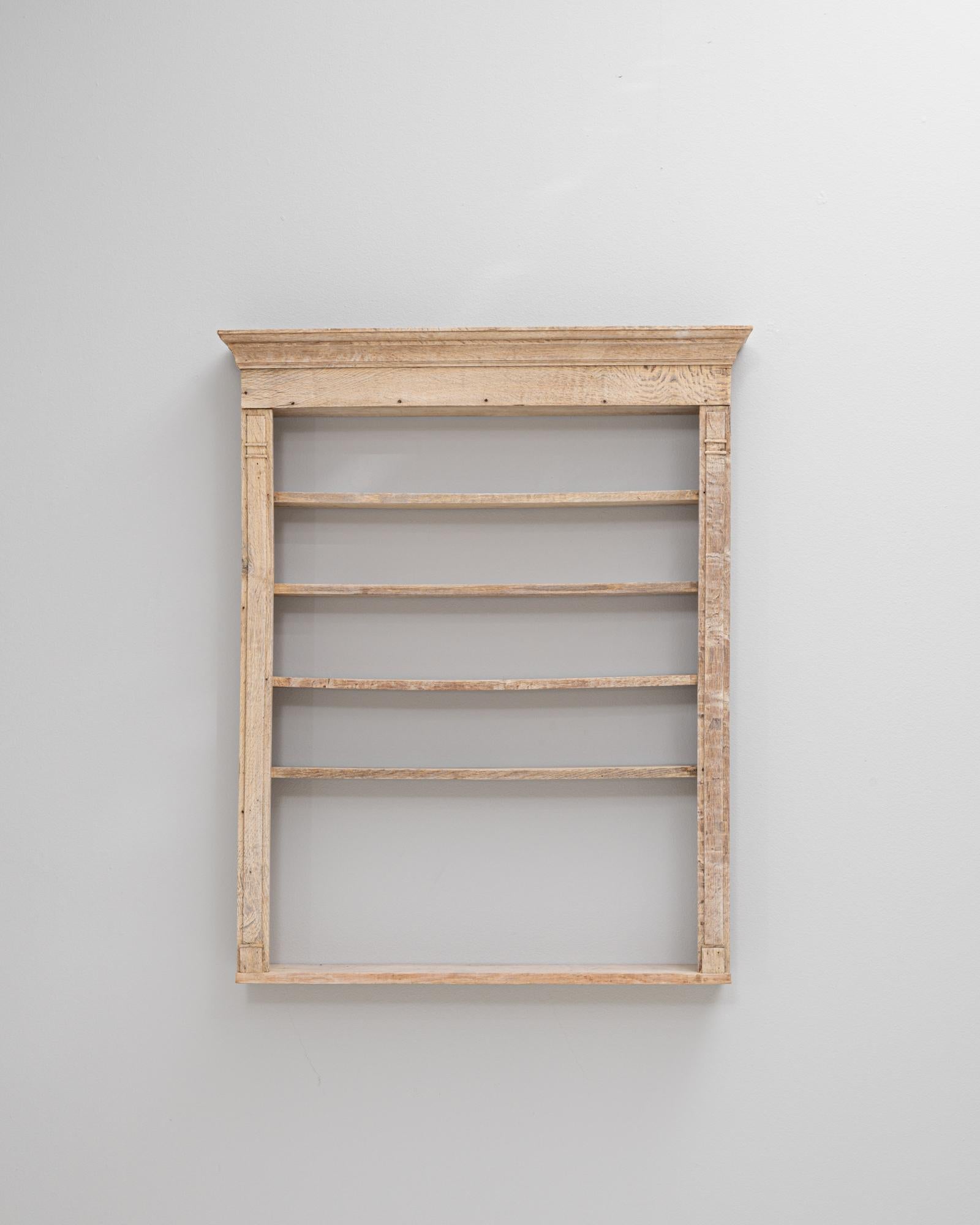Questo scaffale da parete in Oak francese del XIX secolo è un pezzo finemente lavorato che riflette la semplicità e il fascino del design provinciale. Costruito in rovere massiccio, lo scaffale presenta una patina invecchiata naturalmente che ne