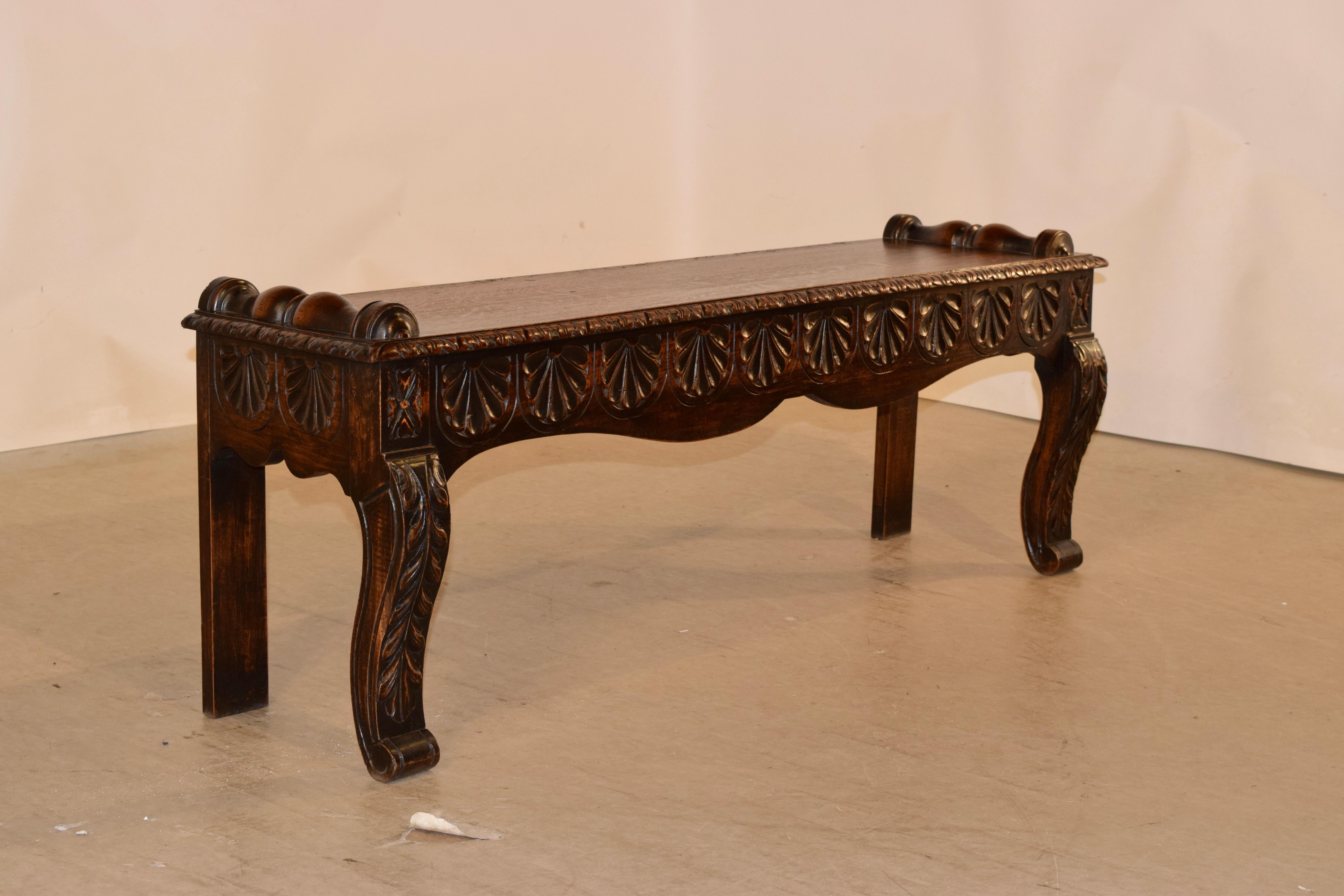 19th century oak window seat from France with a carved and beveled edge around the seat and half applied turnings on the top. The apron is hand scalloped and carved decorated, over simple legs in the back for easy placement against a wall and hand