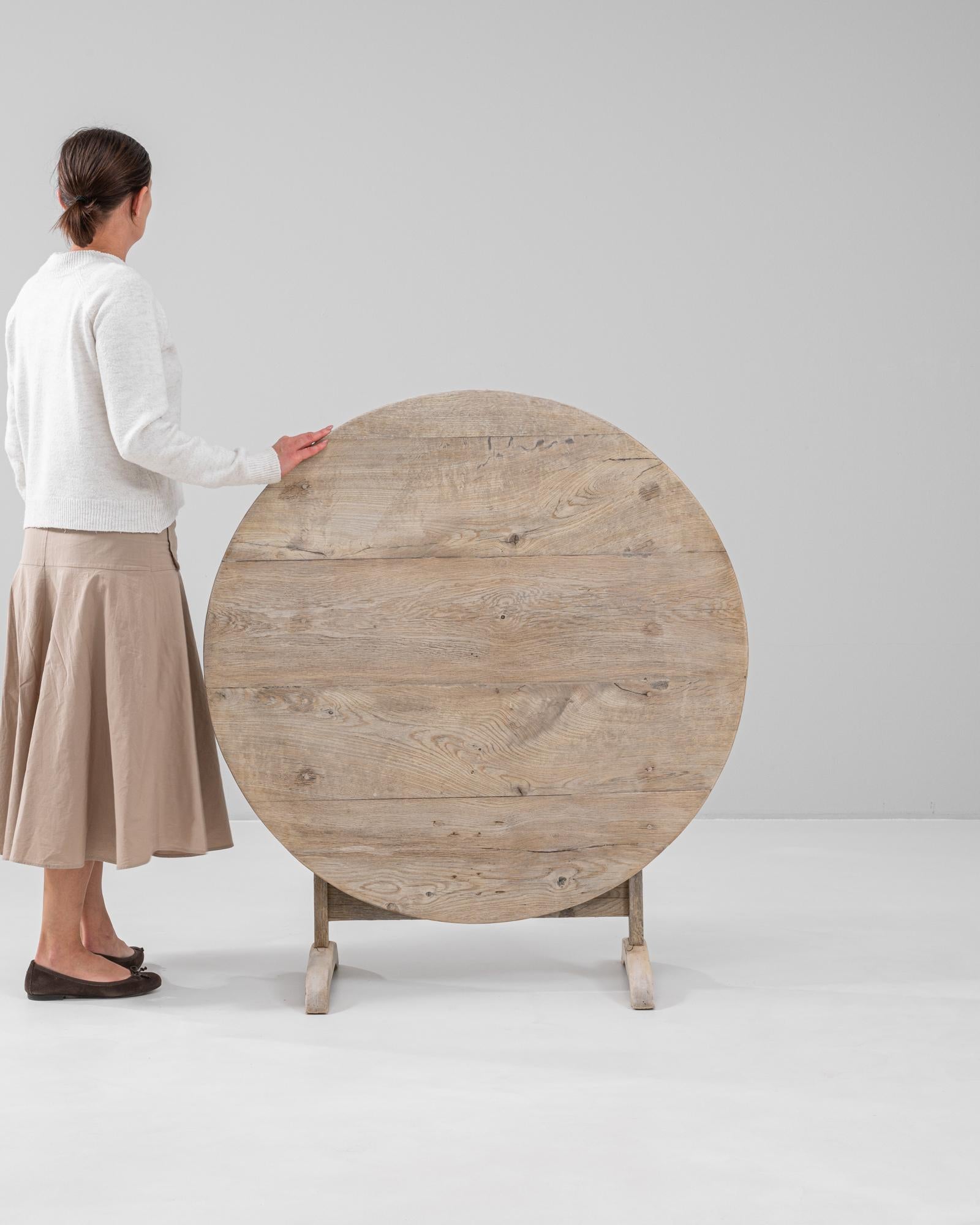 This exquisite 19th Century French oak wine tasting table embodies timeless craftsmanship and rustic charm. Handcrafted from solid oak, it features a versatile tilt-top design, allowing it to be easily folded when not in use. The natural wood grain