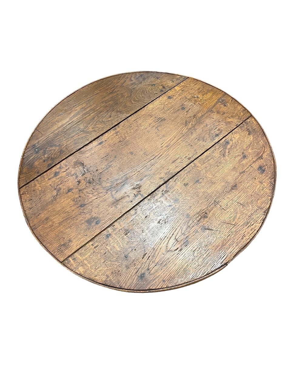 Experience the charm of the French countryside with our Petite 19th Century French Oak wine tasting table. Crafted with meticulous detail, its sturdy oak construction is elegant as well as sturdy. The tilt top adds functionality, while the rustic