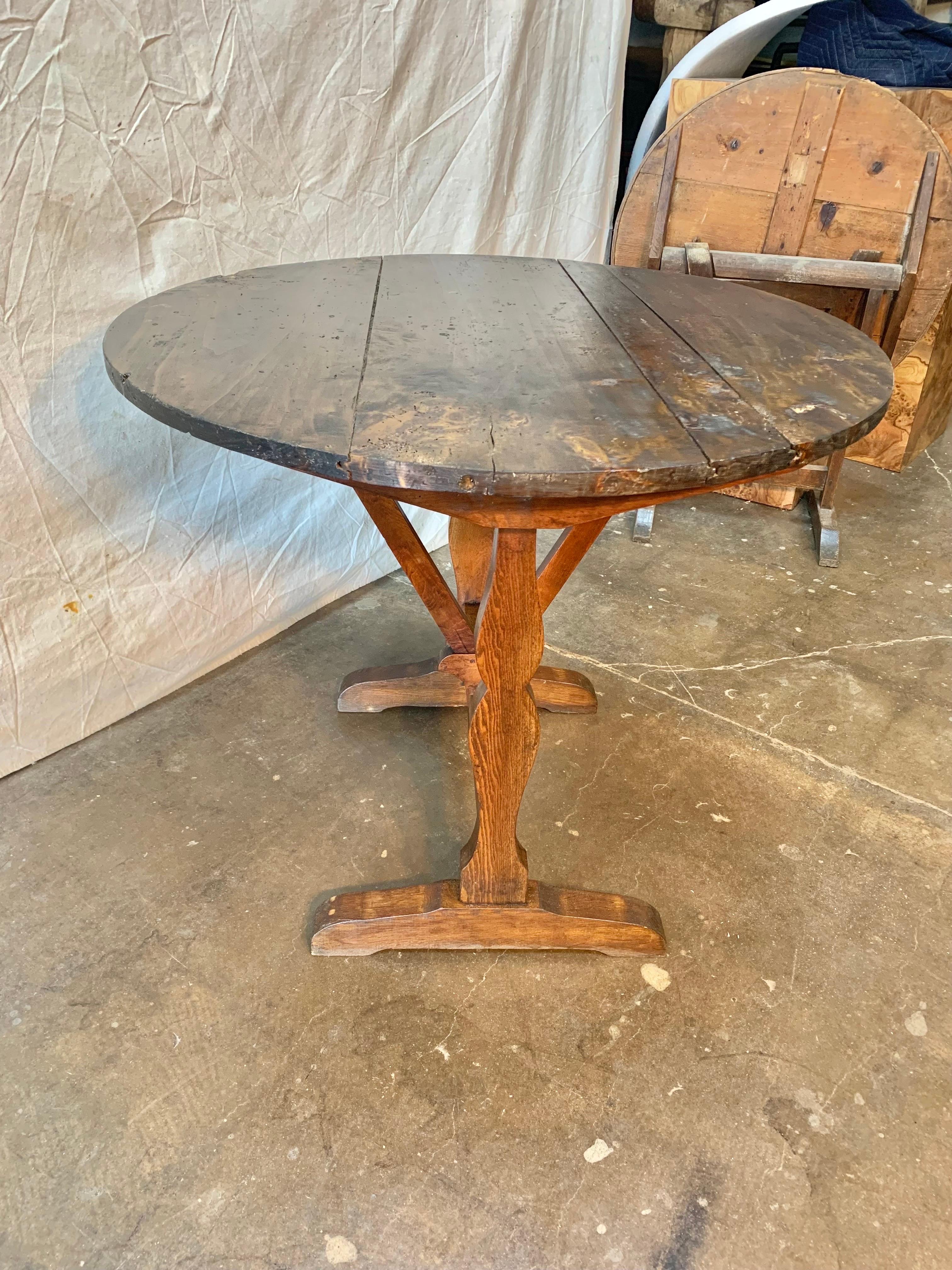 French wine tasting table, also known as a vendage or vigeron table, which was once used in the vineyards of France for tasting wine or enjoying a meal. This table would be suitable for use as a side table or in a wine cellar. Featuring a tilt-top,