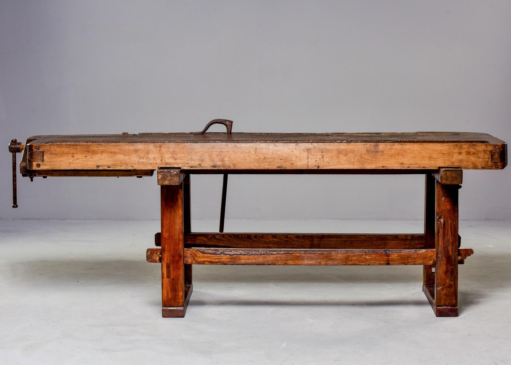French work bench in dense oak with attached hand forged iron tools including a vise at one end, circa 1880s. Authentic wear and patina to top. Versatile height and size make this piece usable as a unique console, bar or server. Unknown maker.