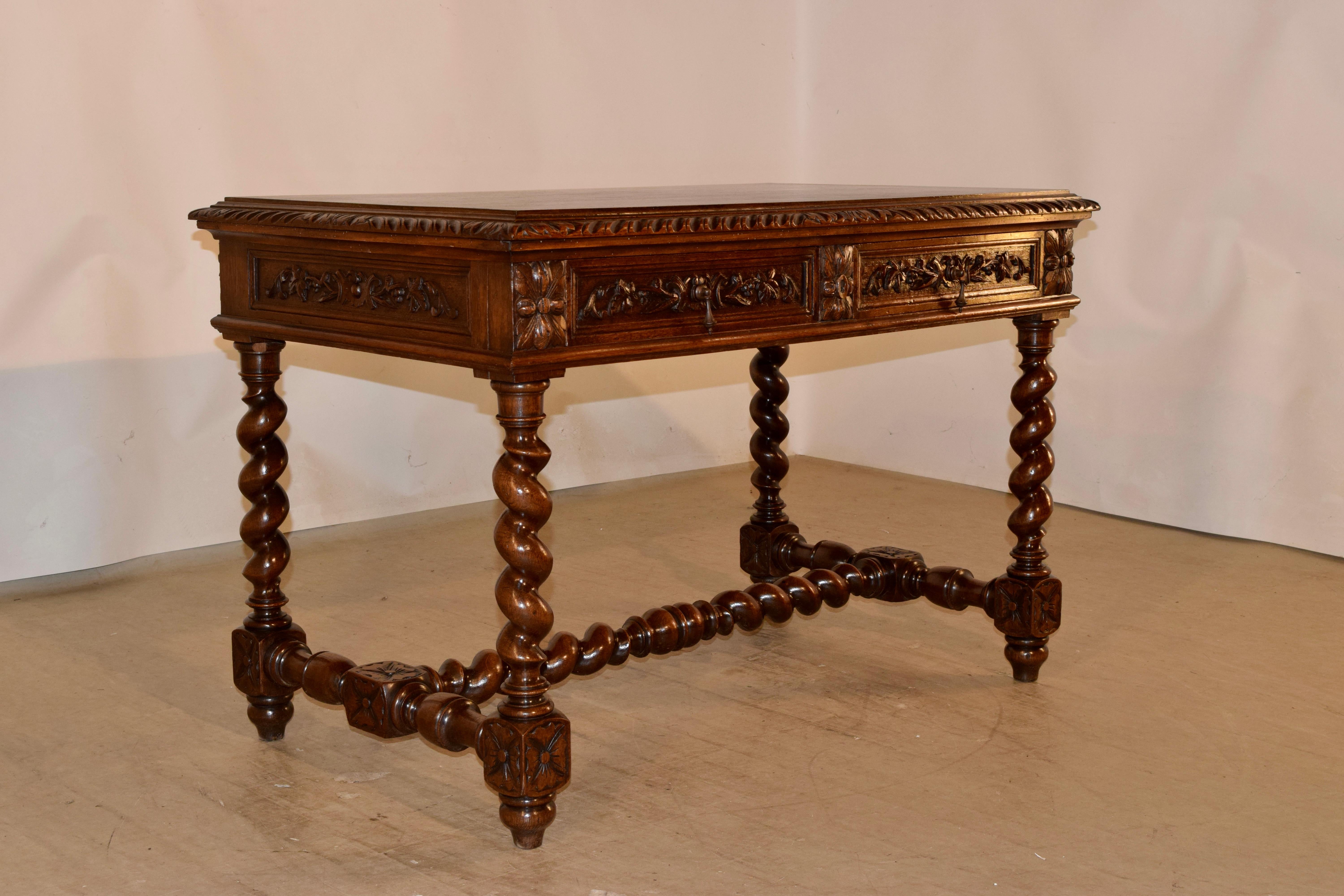 19th century oak writing desk from France with a hand carved and beveled edge around the top over a molded and hand carved decorated apron on all four sides for easy placement in any room. There are two paneled and hand carved drawers in the front