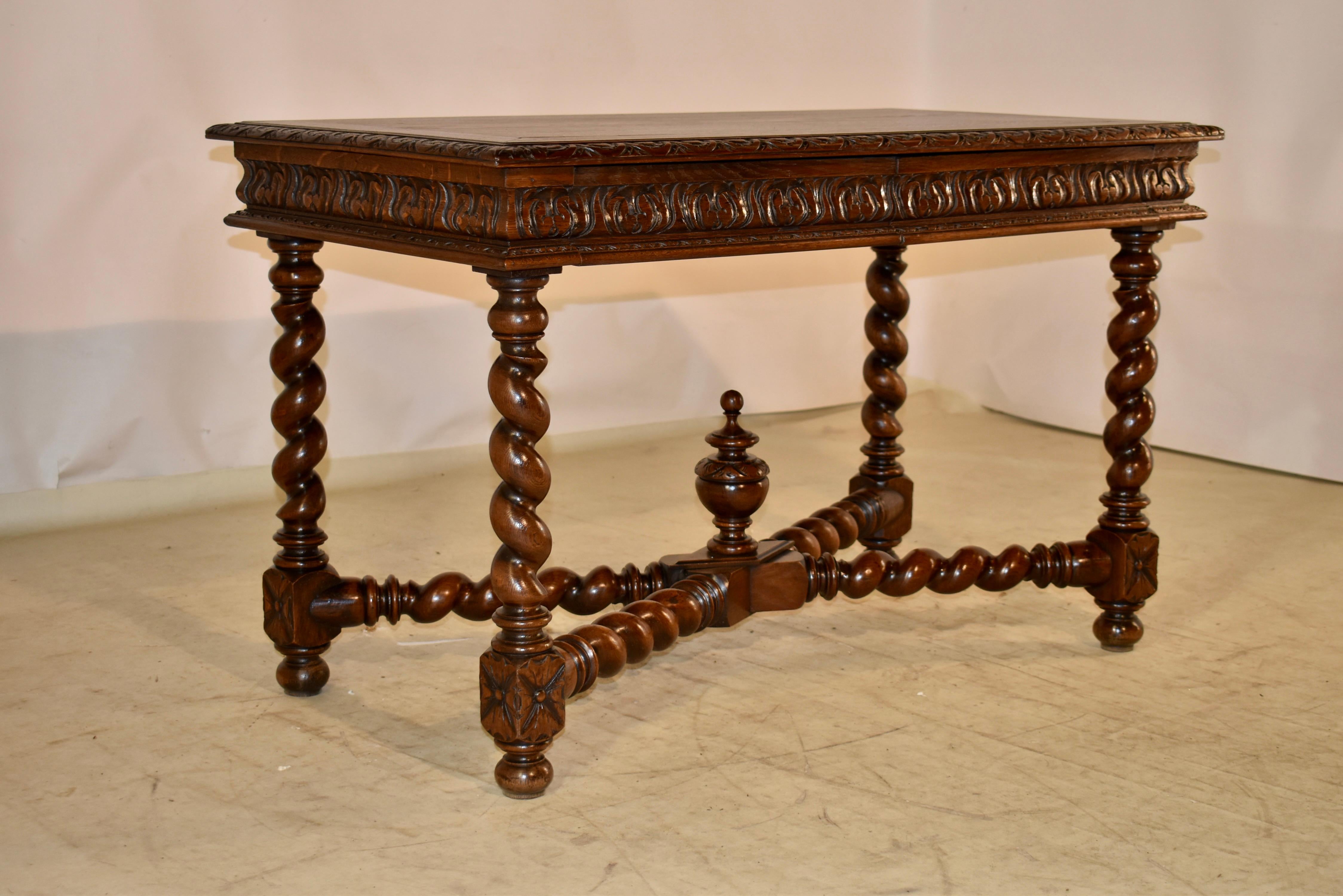 19th century oak desk from France.  The top is banded and has beveled and hand carved decorated edges.  The top follows down to molded and hand carved decorated aprons on all four sides , for easy placement in any room.  There are two drawers in the