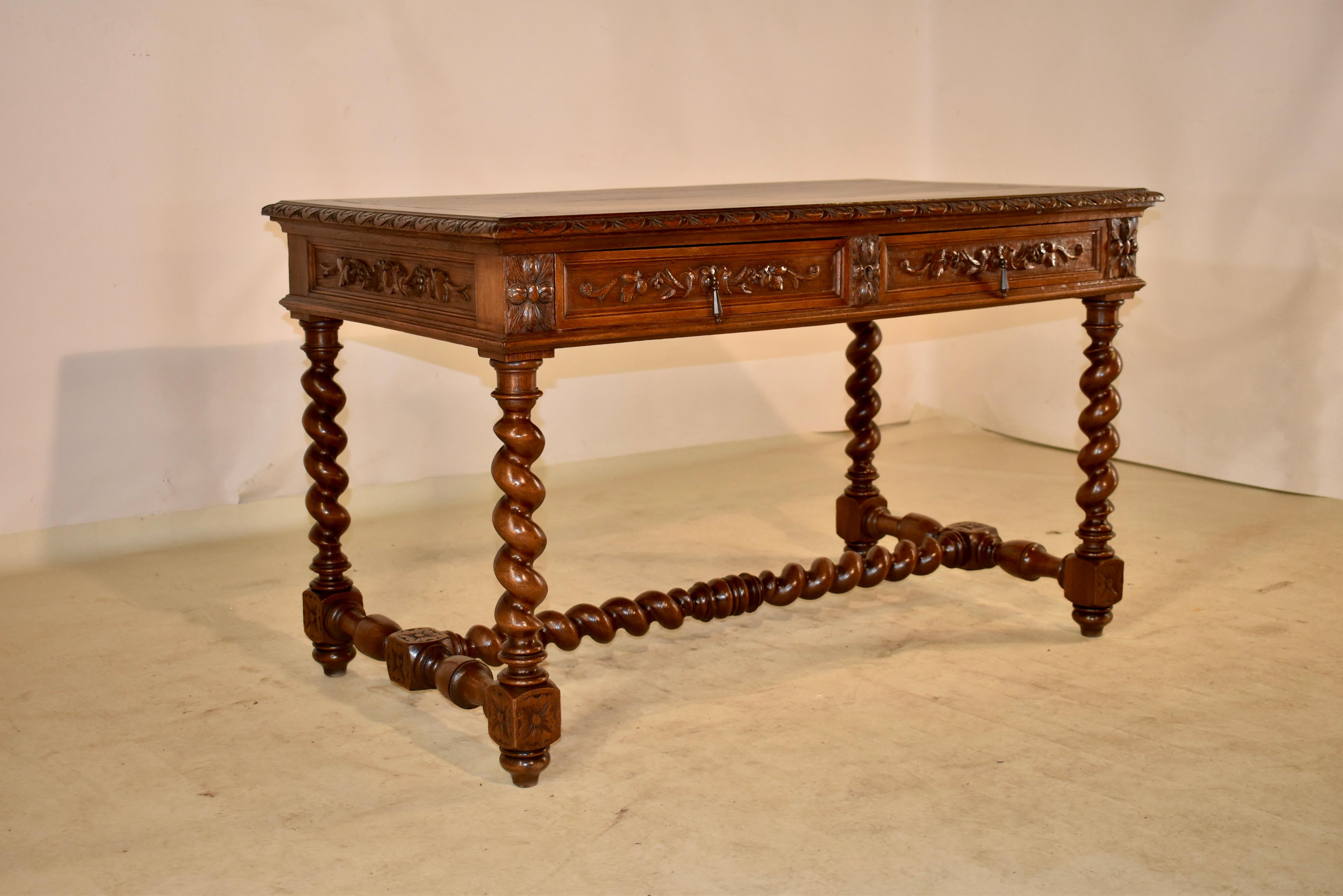 19th century oak writing table from France with a banded top, which also has a lovely hand carved and beveled edge, following down to paneled aprons, all with hand carved decoration. the carving is on all four sides for easy placement in any room.