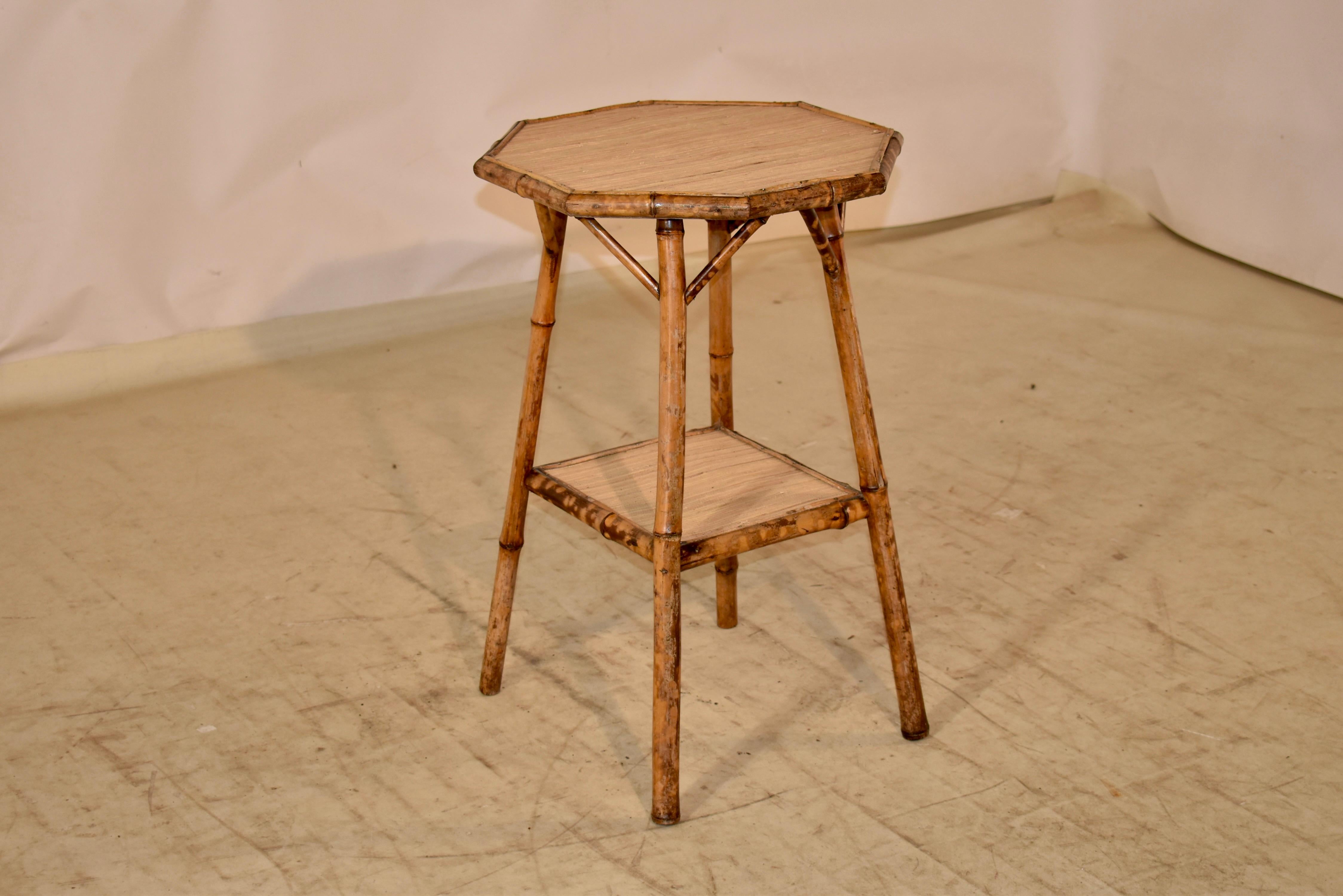 19th century bamboo side table from France.  The top is octagonal in shape and is supported on splayed legs, which are joined at the bottom by a lower shelf, both covered in seagrass.  This table has a lovely shape and color, and would be an
