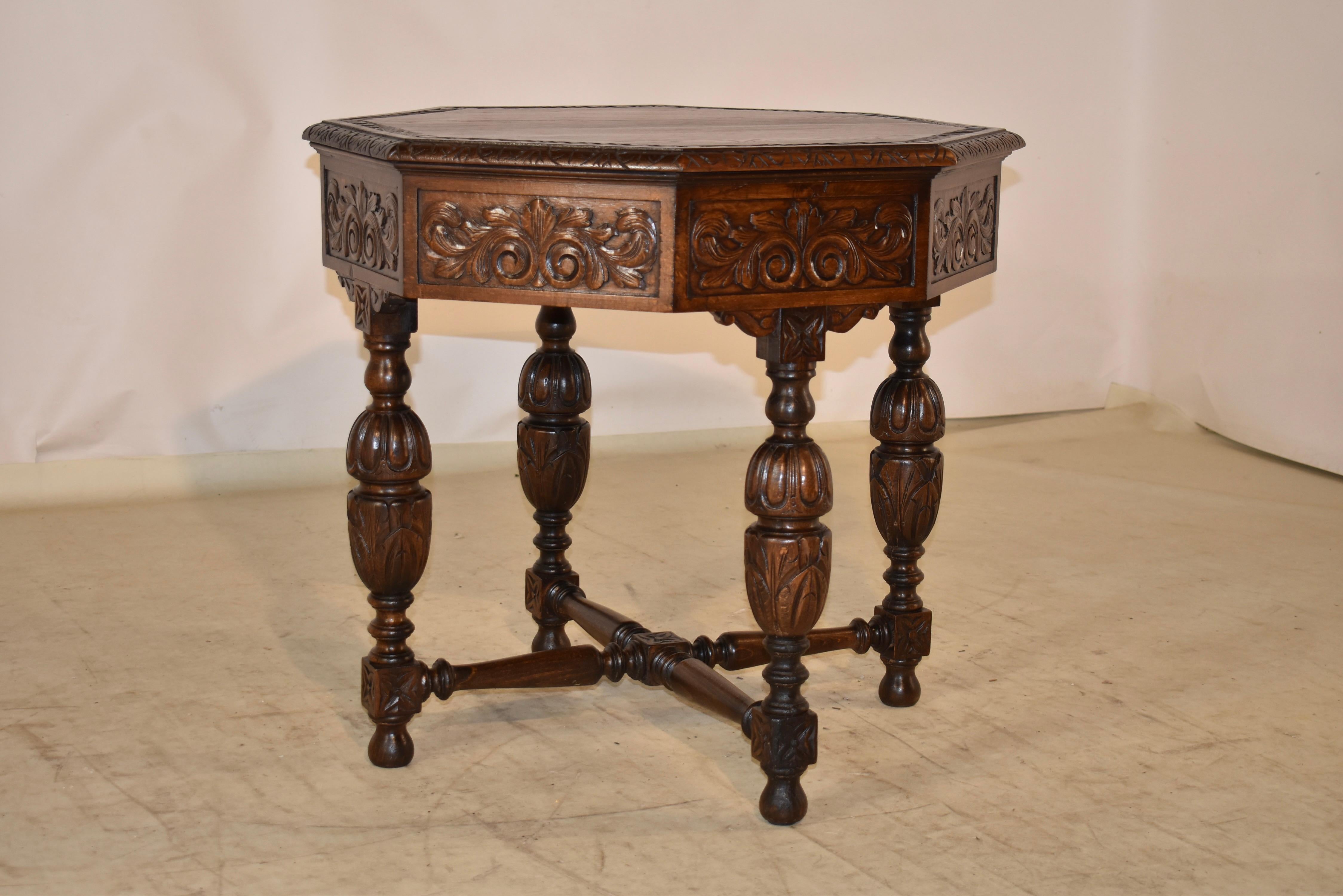 19th century oak side table from France with an octagonal shaped top. The top has a carved decorated band inside a beveled and carved decorated edge. The top follows down to a lovely carved and faceted apron, which is carved on all sides for easy