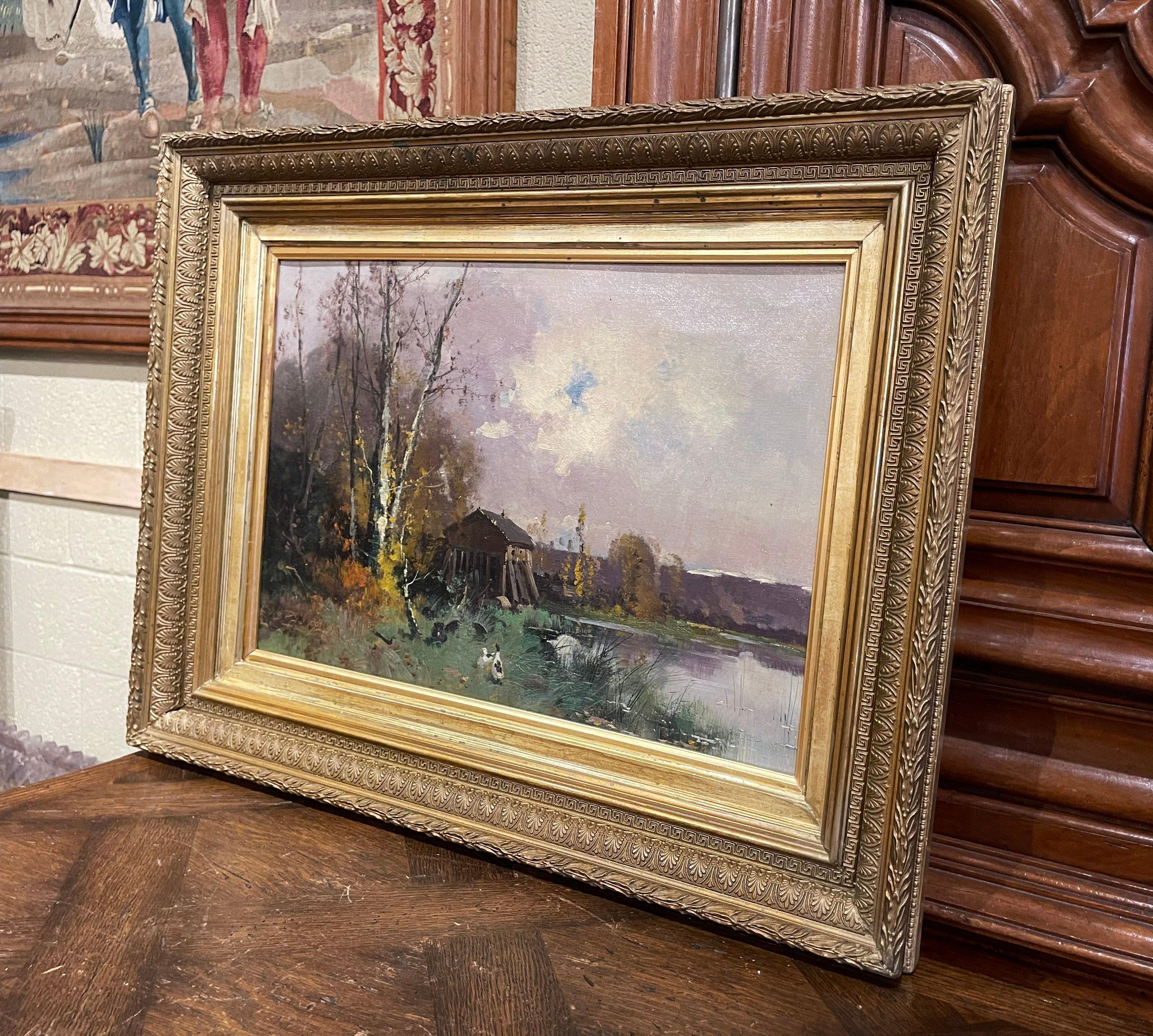This 19th century impressionist painting was crafted in France, circa 1890. Set in a carved giltwood frame, the artwork painted on canvas, illustrates a picturesque, countryside landscape scene with a forest, barn, chickens, ducks, and a pond in the