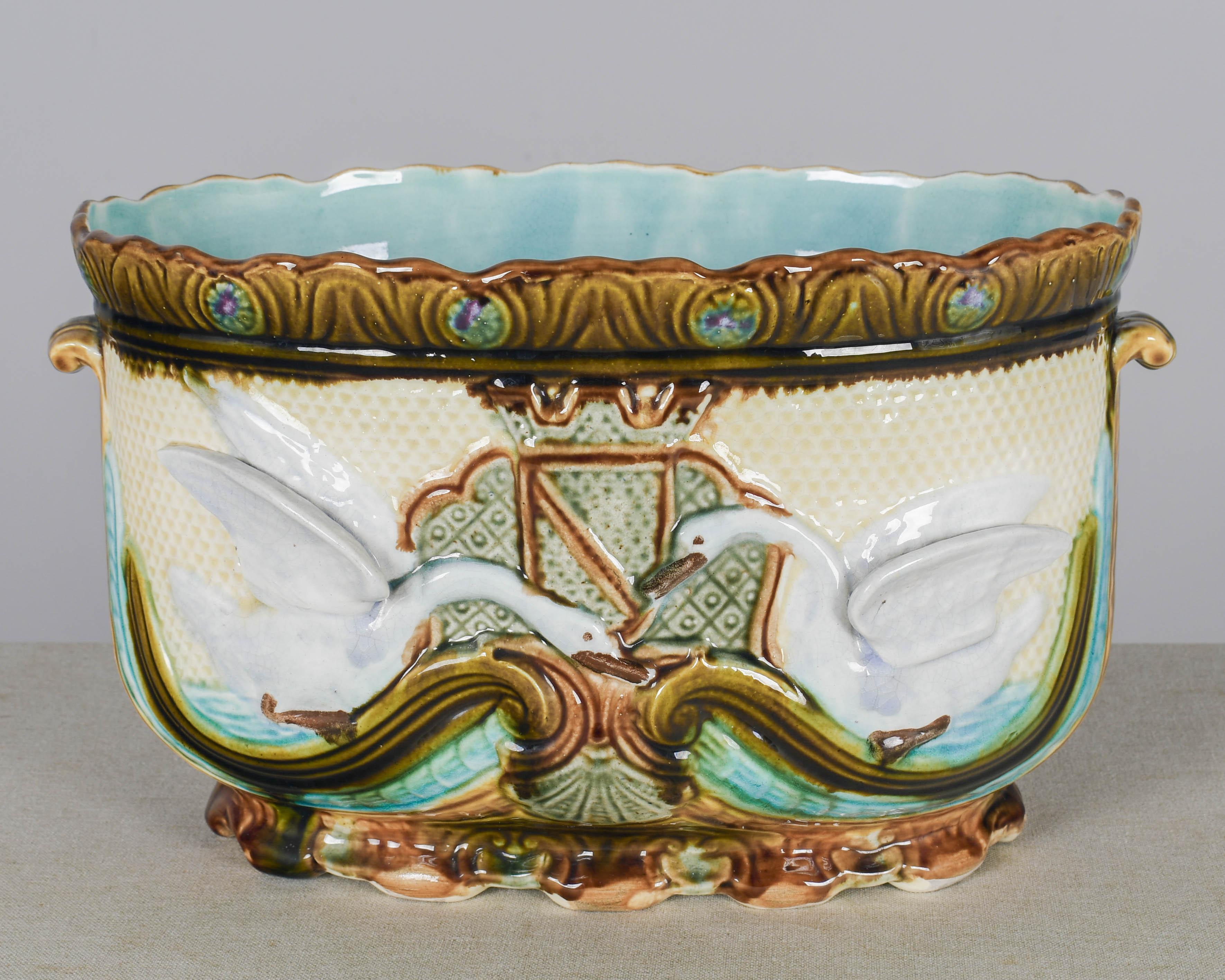 A large late 19th century French Barbotine jardiniere, or cache pot, with swan motif. Hand-painted glazed ceramic with vibrant color and turquoise blue interior. Perfect for the display of orchids or ferns. Attributed to Onnaing. Marked on bottom