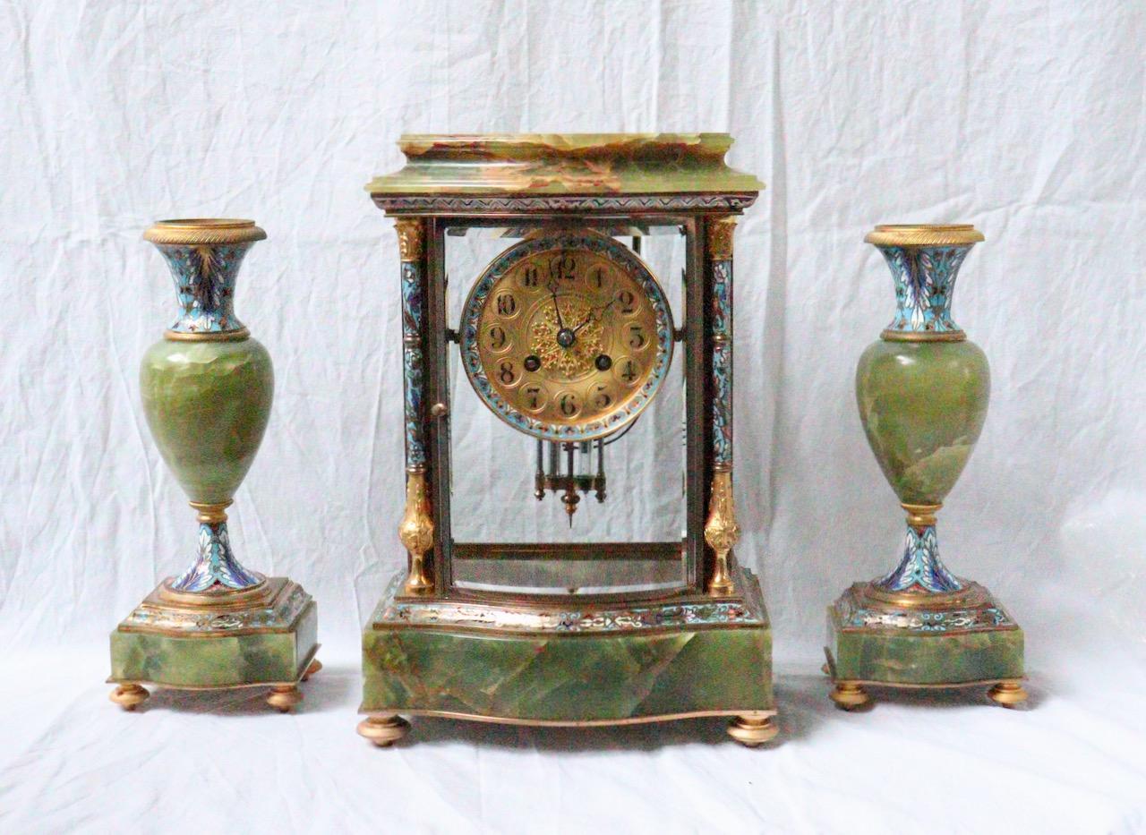 A 19th Ccentury French Ormolu and Champlevé Enamel Three-Pieces Clock Garniture

This three-pieces antique French clock set is composed of a mantel four bevelled glass clock, having a pair of Corinthians columns with enamel design either side of