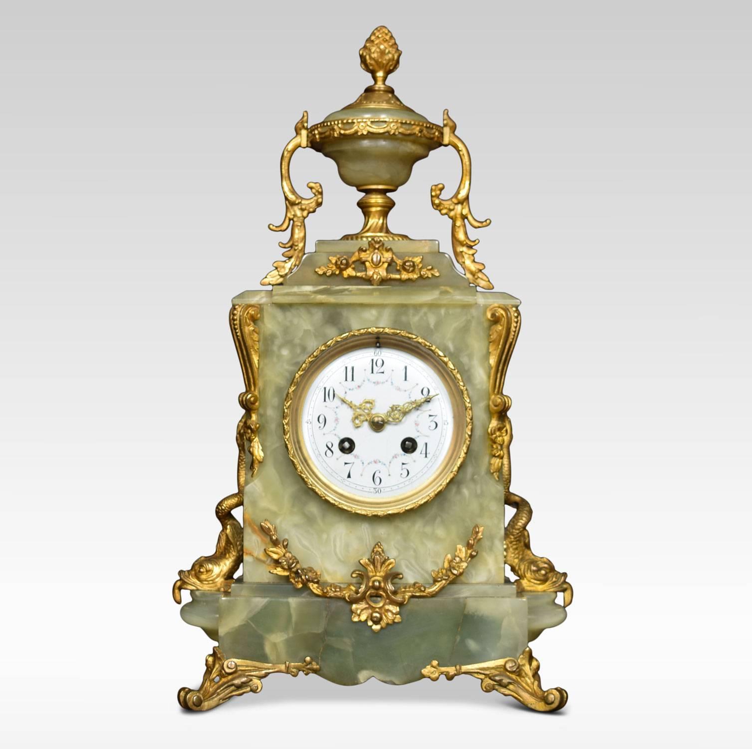 19th century French onyx and gilt metal clock set, the white enamel dial decorated with floral detail, the eight day movement striking on a bell, the clock case crested with pineapple finial urn with dolphin supports to the sides terminating in