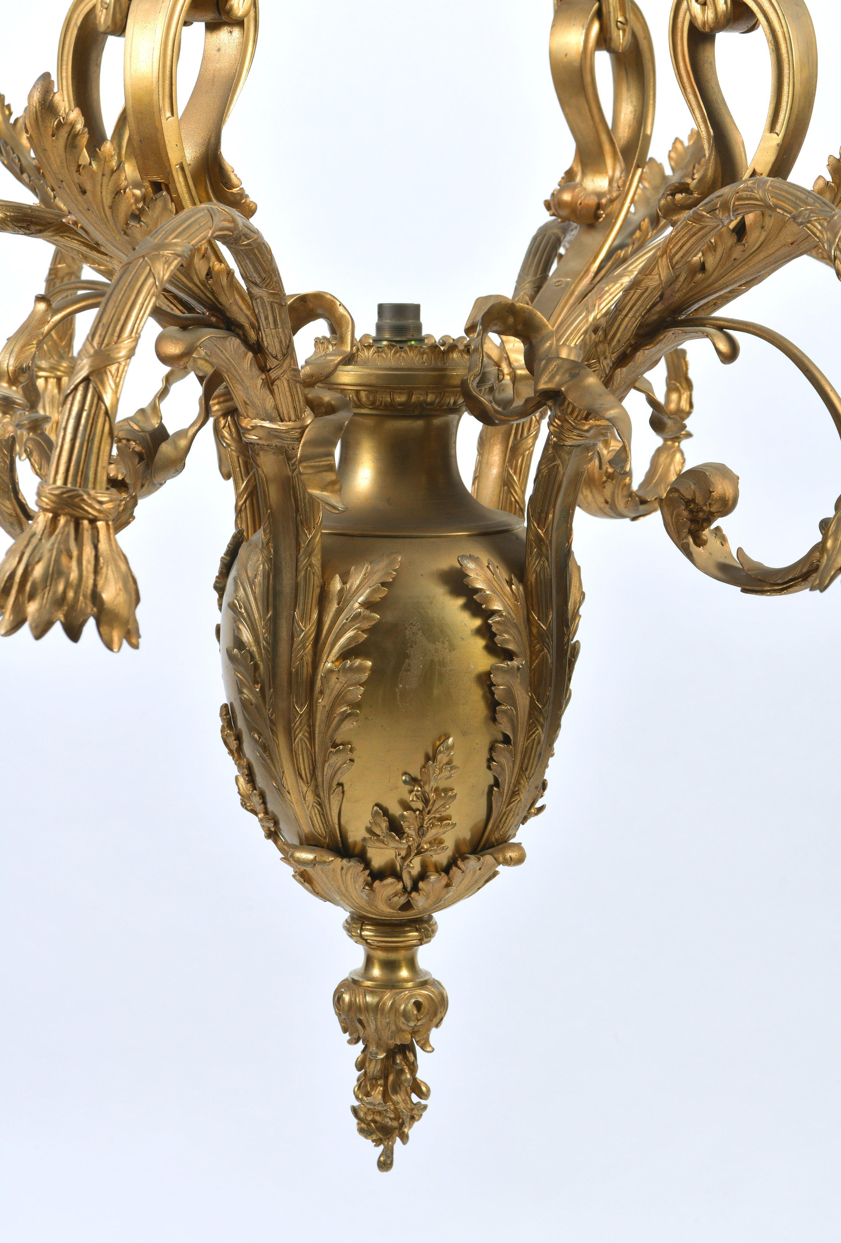 This stunning and highly ornate French ormolu chandelier features 9 curved arms surrounding an oval bulb centre suspended by 4 ‘tied fabric’ styled supports. It measures 37 ½ in – 95.5 cm in diameter and 53 in – 134.7 cm in height. The attention to